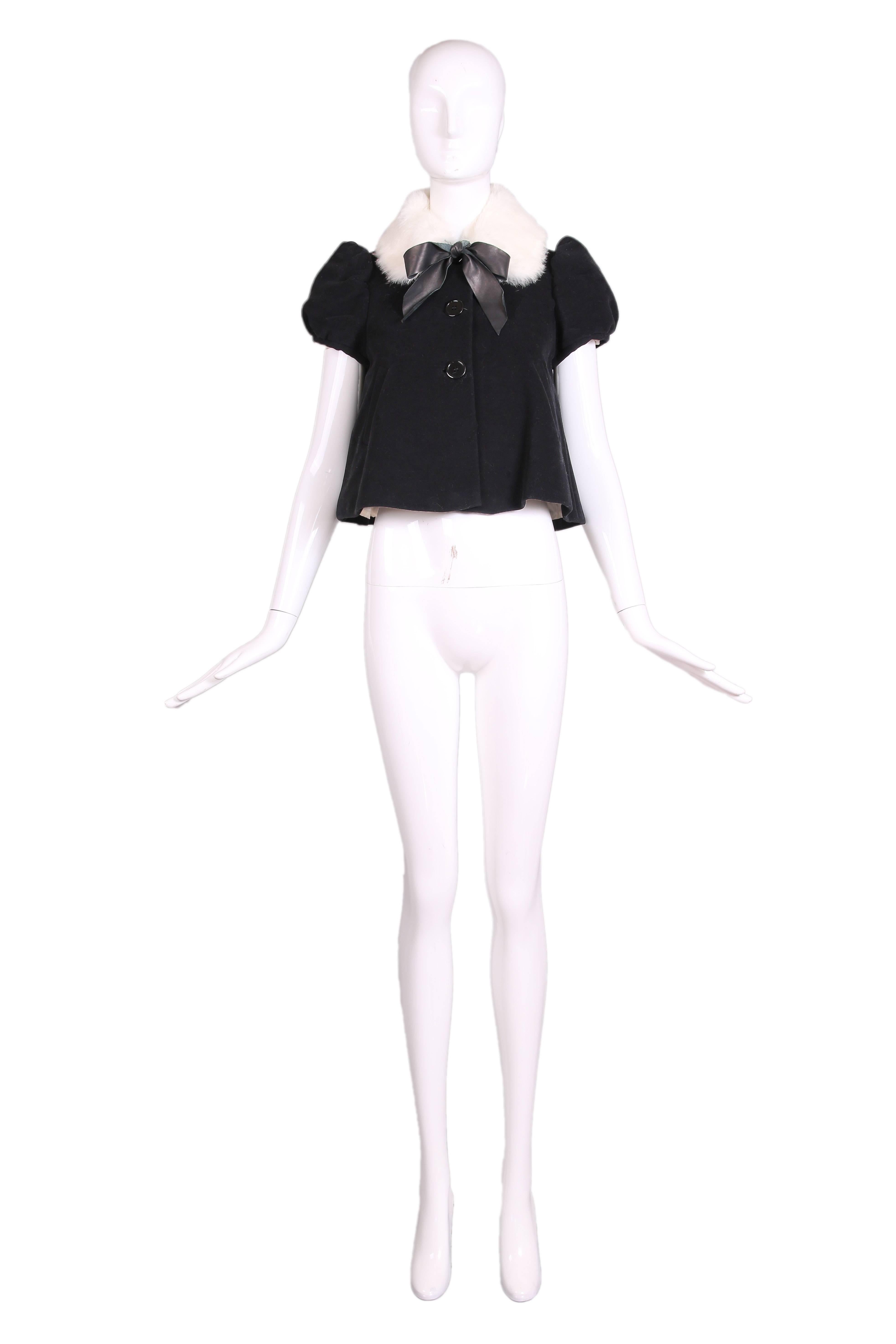 Jean-Paul Gaultier cap-sleeved black cotton velvet trapeze shaped jacket top with leather neck ties, oversized buttons and a white rabbit fur collar. Entirely lined, in excellent condition. Size 4 US. Please see measurements.
MEASUREMENTS:
Bust -