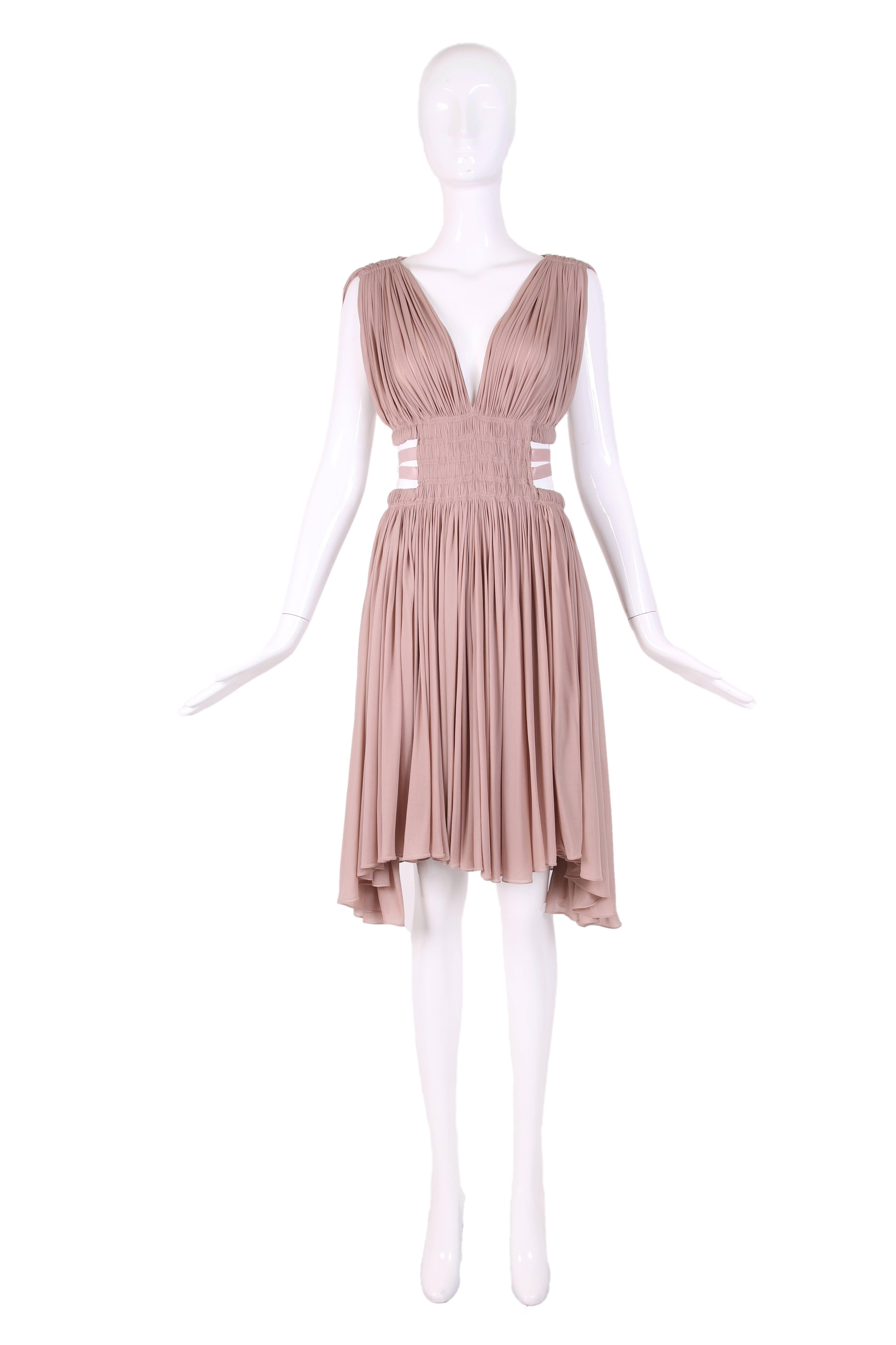 Alaia blush pink mini dress with Grecian draping and gathers. There are there are cut-outs at the waist line with 3 elastic bands that hug the sides, waistline and back. The dress in done in a cupro fabric which is cotton with the hand of a silk