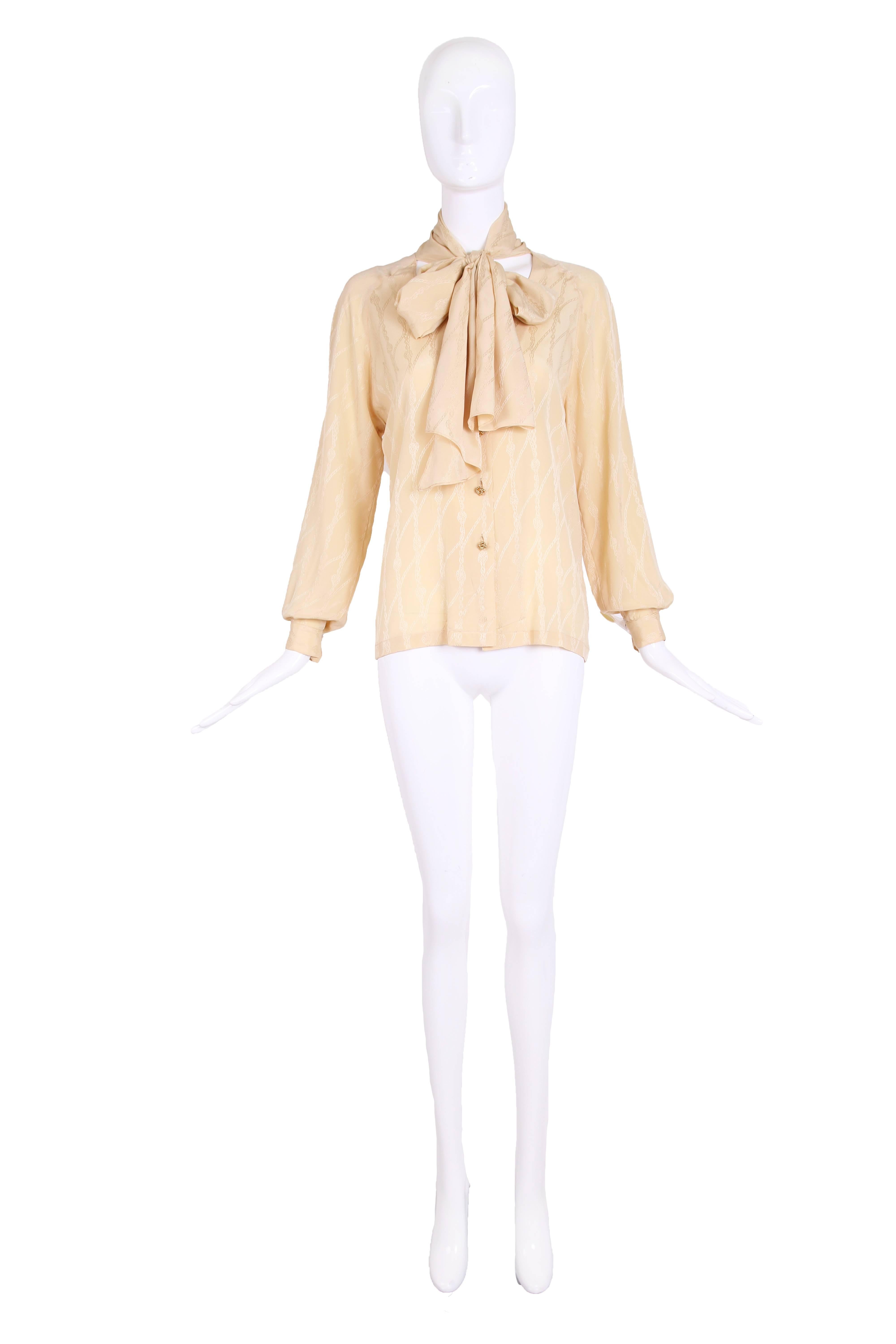 1970's Hermes creme silk blouse with chain print & gold tone metal buttons. Has scarf attached at back neck which can hang down in a loose loop or be tied in a pussy bow. IN excellent condition - size 46 though most likely smaller due to modern