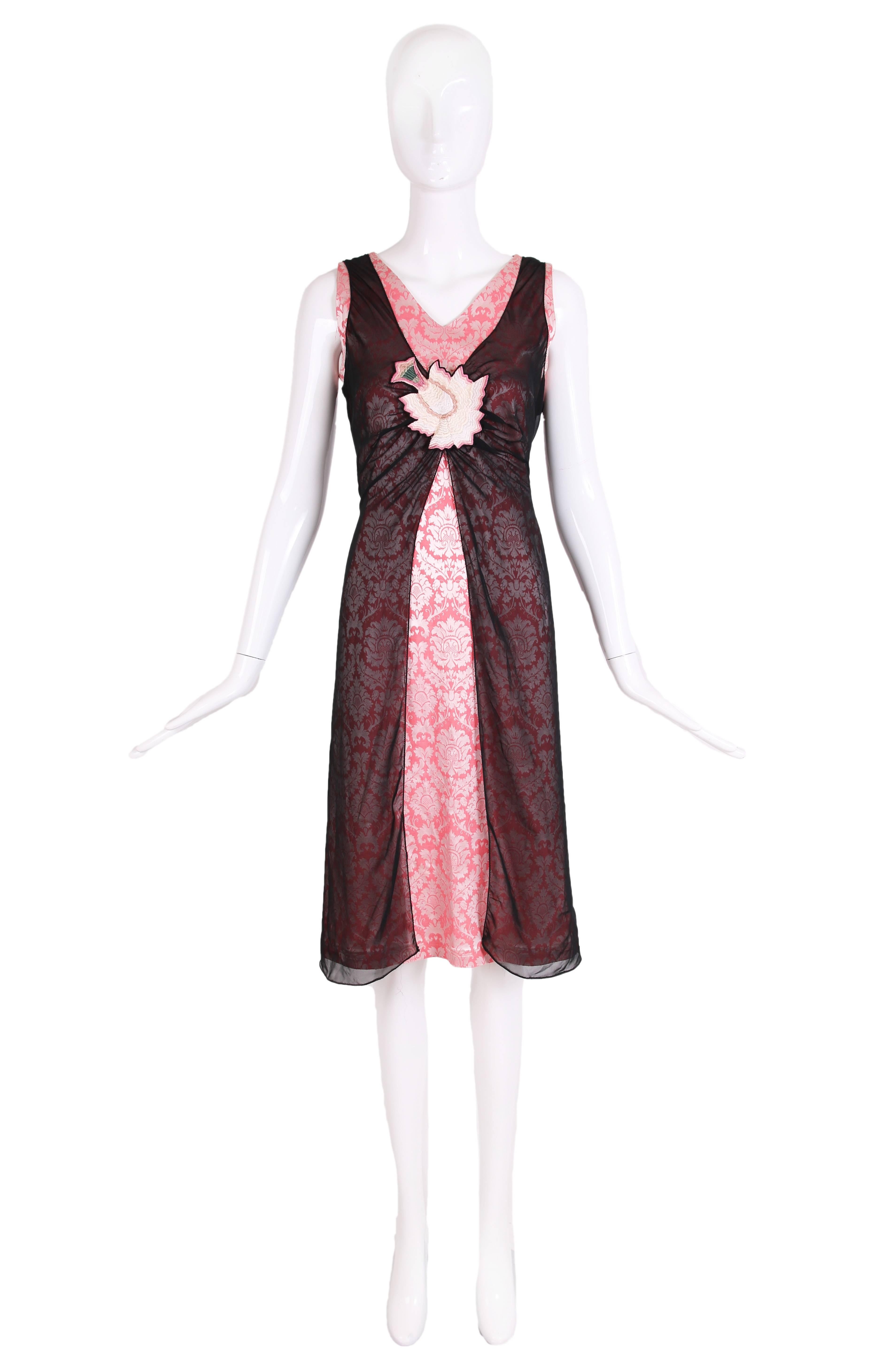 Alexander McQueen, circa 1996 sleeveless dress comprised of two layers: a stretch pink brocade and a transparent black stretch fabric on top, embellished with a single embroidered flower at the front. Zipper closure at back. In excellent condition.