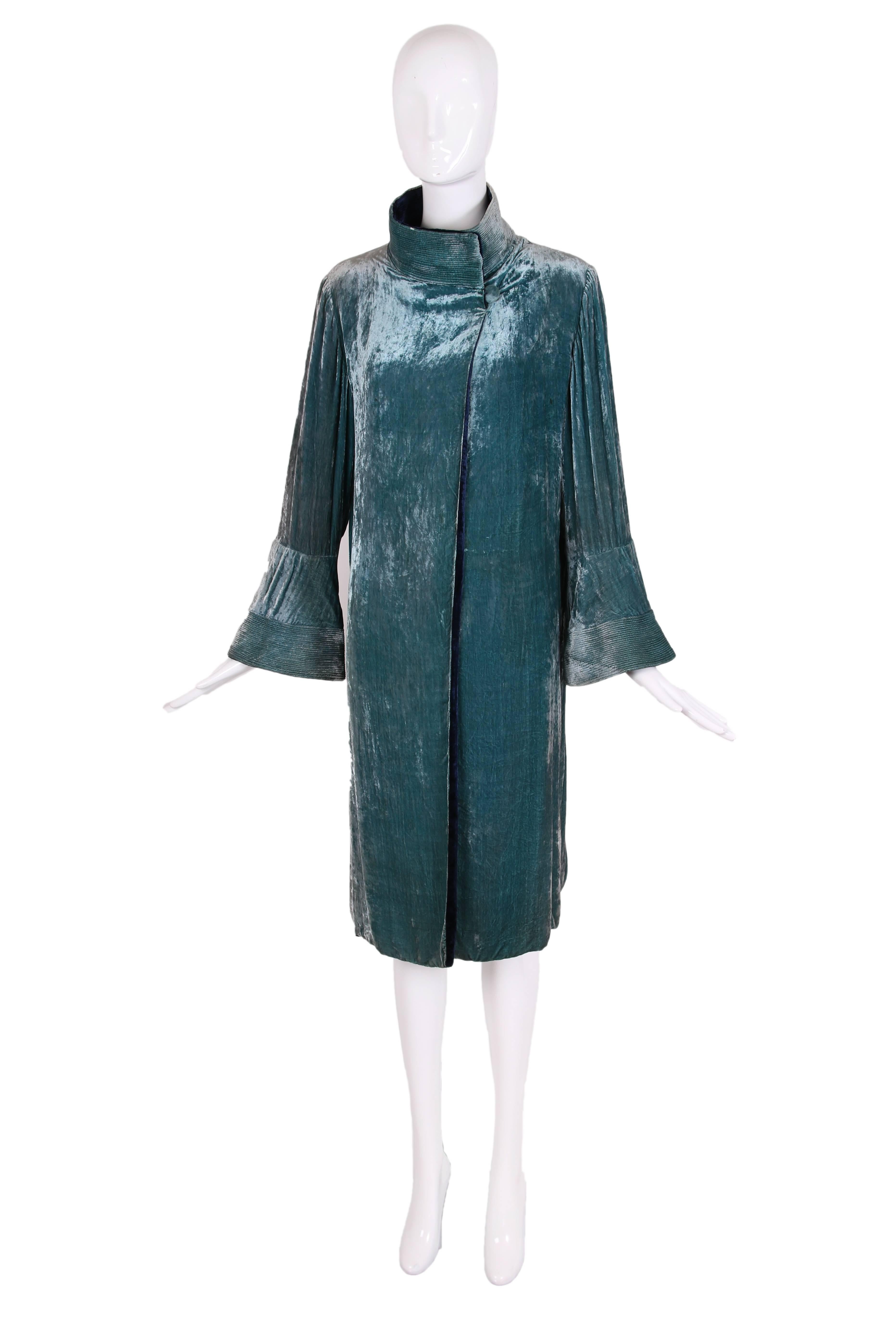 Circa 1925 attributed to Jeanne Lanvin silk velvet reversible coat in peacock blue on one side and midnight blue on the other. There are small gathers where the sleeves meet the armholes, quilted and overstitched design elements at the cuffs and