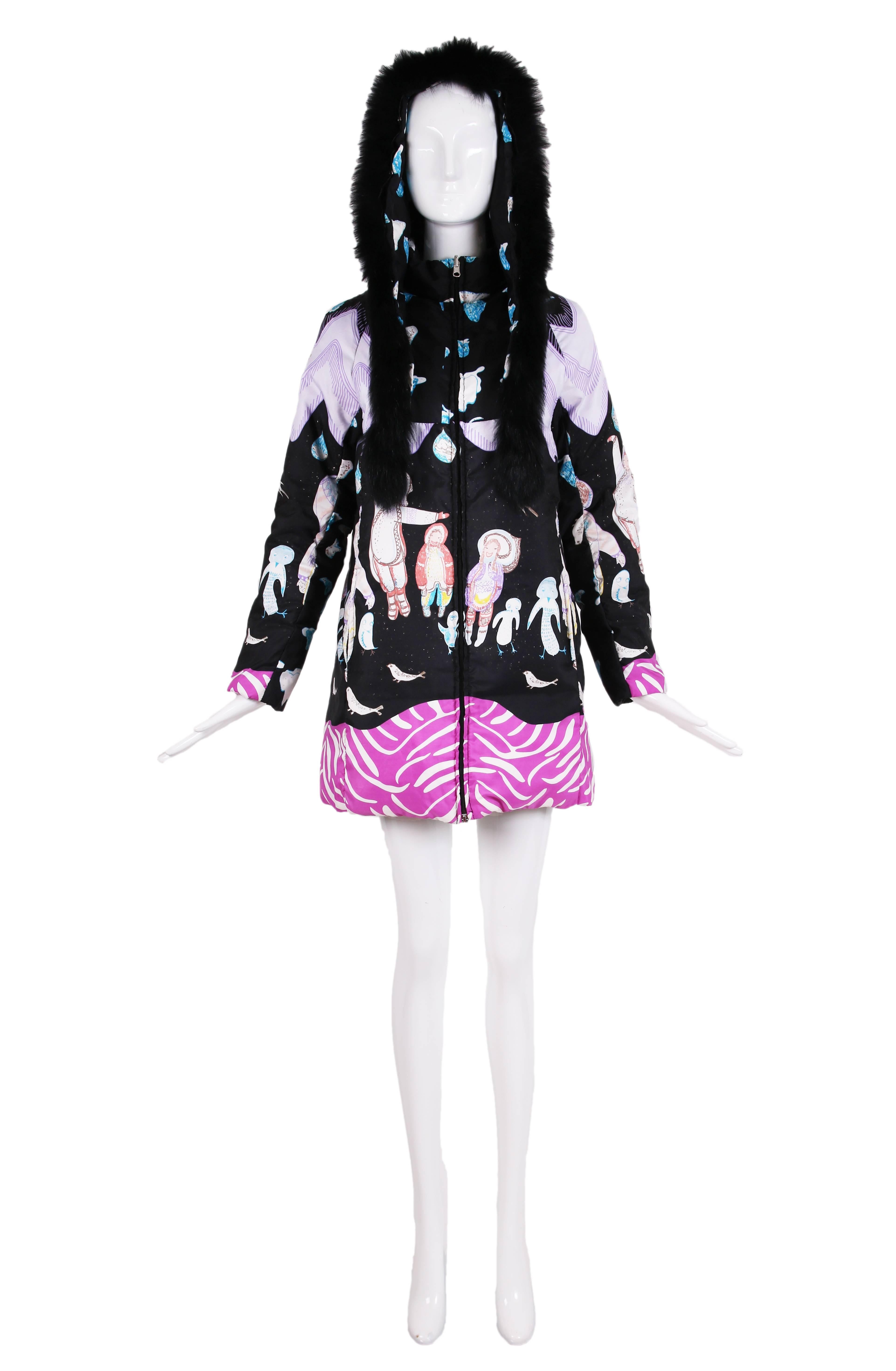 Tsumori Chisato signature style whimsical reversible down zipper front jacket with an asymmetric printed winter scene featuring a snowy landscape filled with smiling Eskimos, penguins, seals and a myriad of abstract/geometric shapes. The fur-trimmed