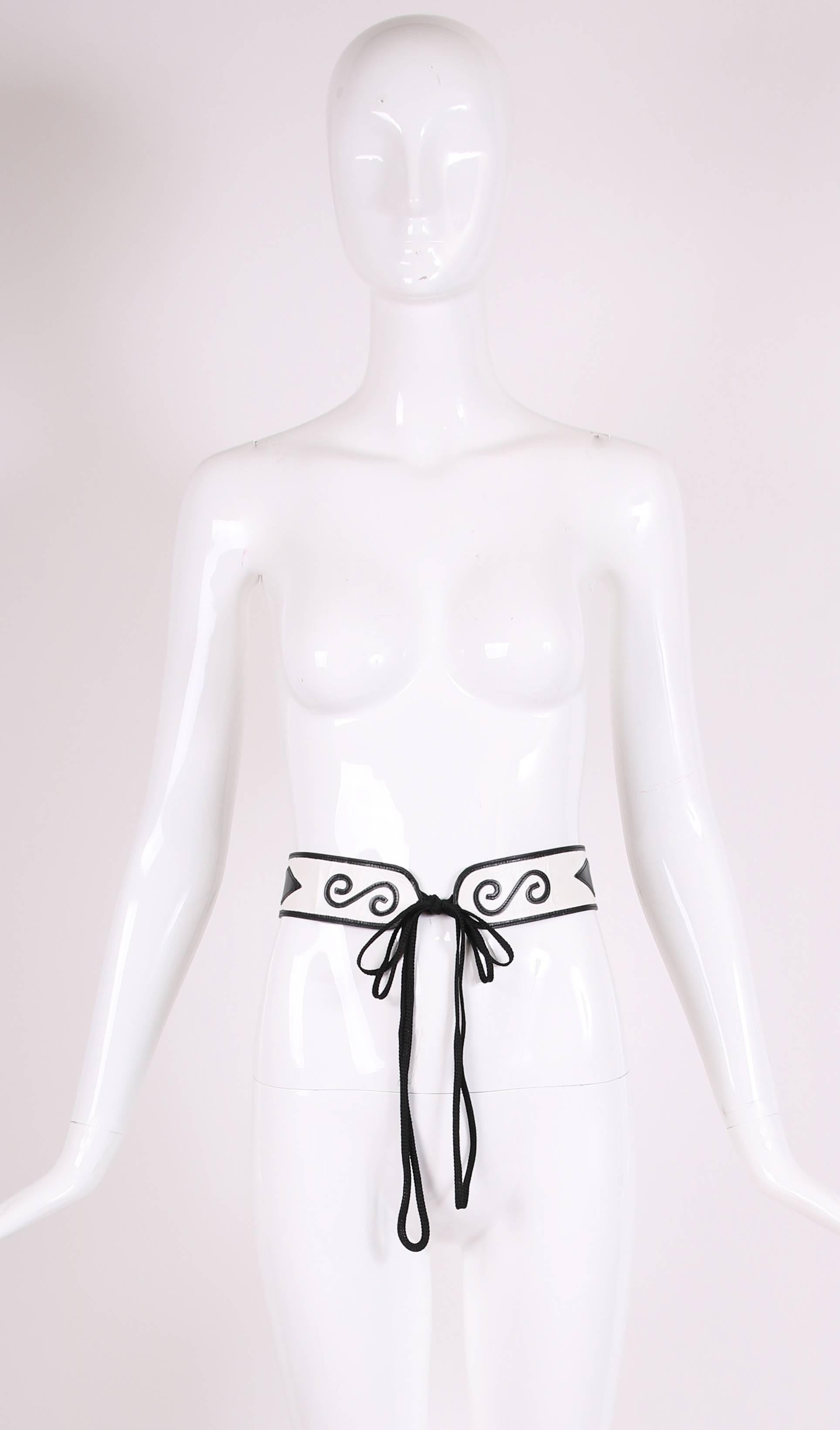 1970's Yves Saint Laurent haute couture white leather belt with black leather design. Belt attaches at either end to a double cord closure.
MEASUREMENTS:
Length (of only the leather part) - 25"
Width (of leather part) - 2"
Length of belt