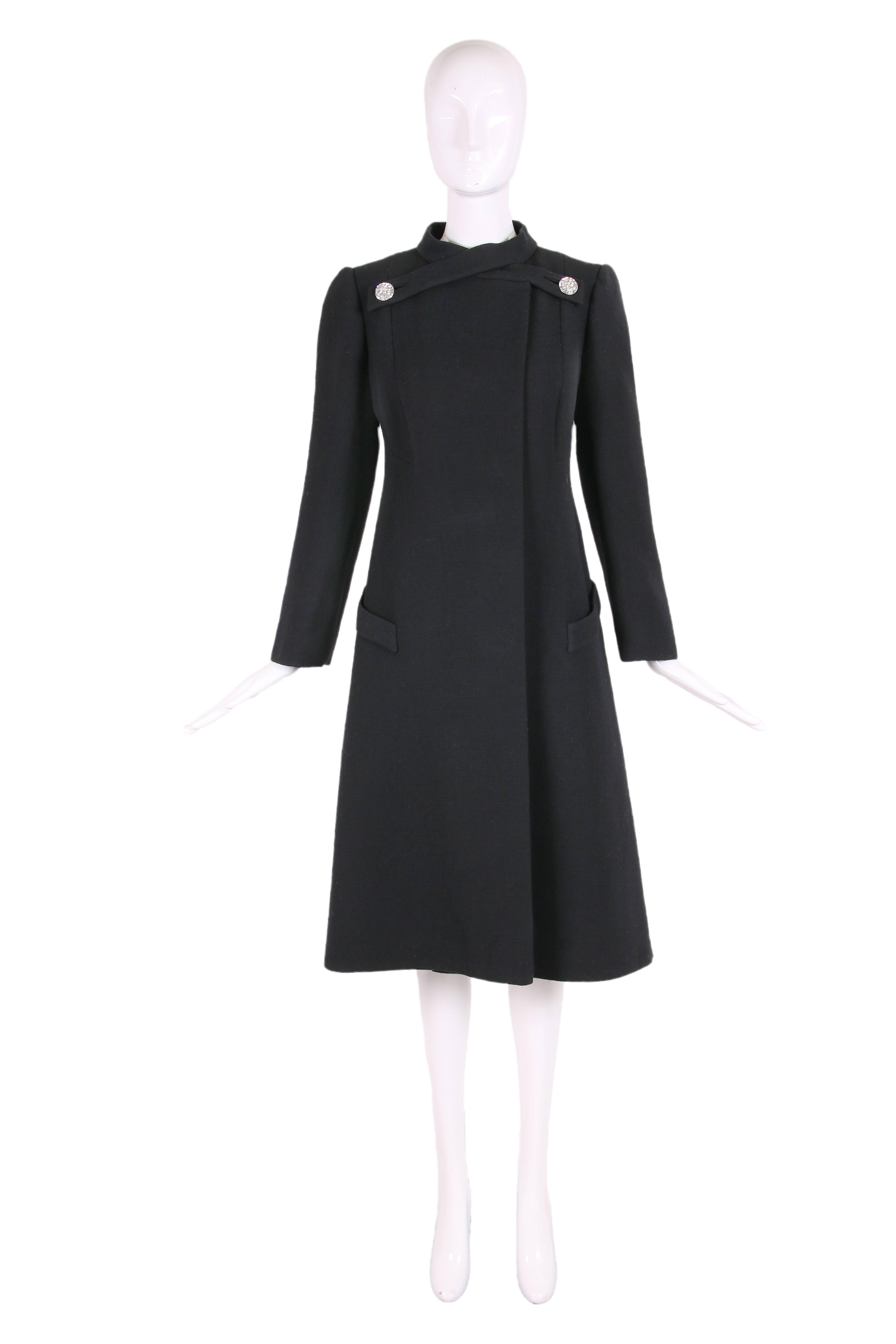 1970's Pauline Trigere black wool coat with criss-cross rhinestone button fastener at neckline - entirely lined in silk. In excellent condition - the rhinestone buttons at the back are not original. No size tag - please consult