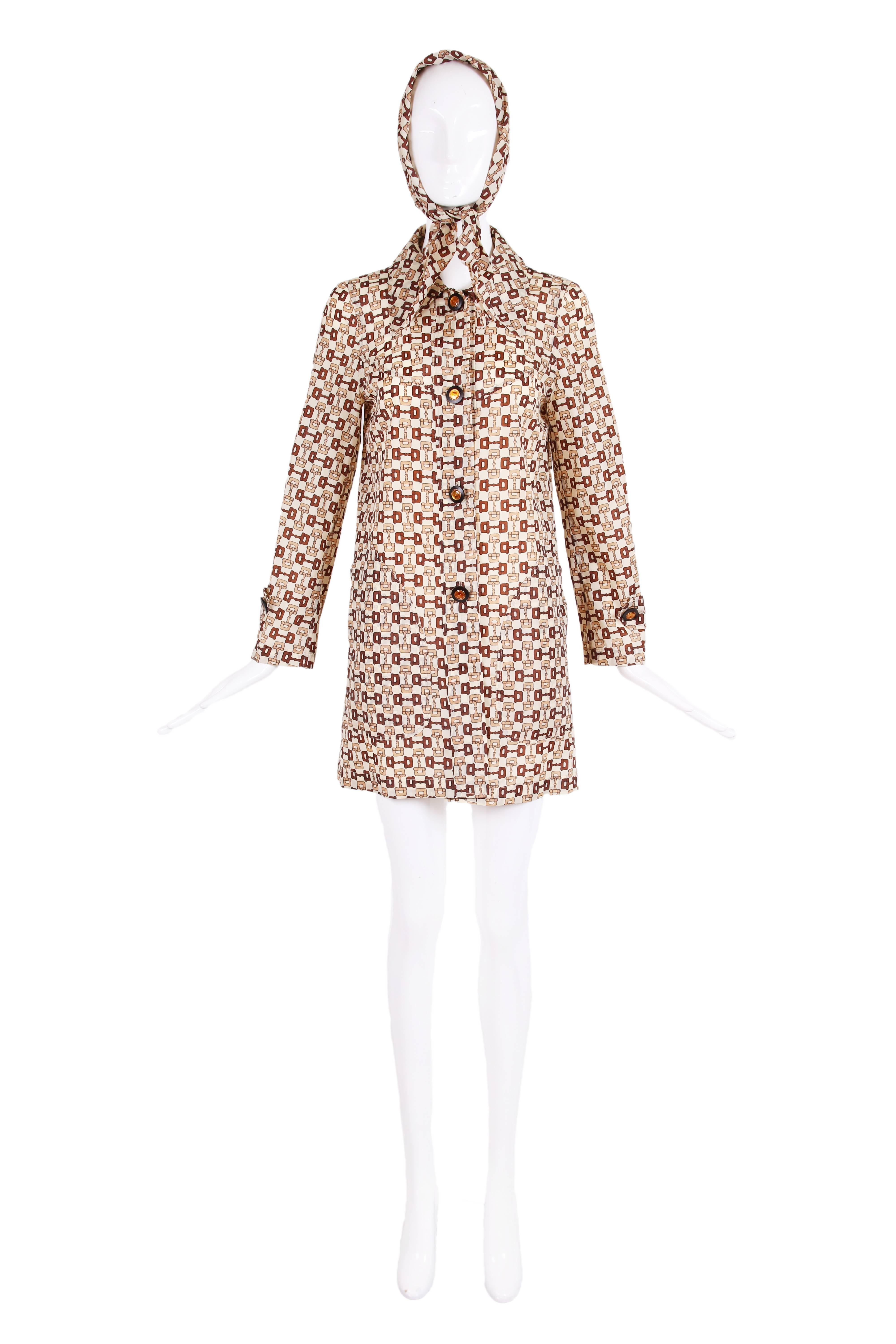 1970's Gucci iconic horsebit print raincoat w/head scarf in shades of cream, tan and brown. Gucci logo included in print in three places. Features two excellently designed frontal pockets and four glazed Gucci button closures down center front and