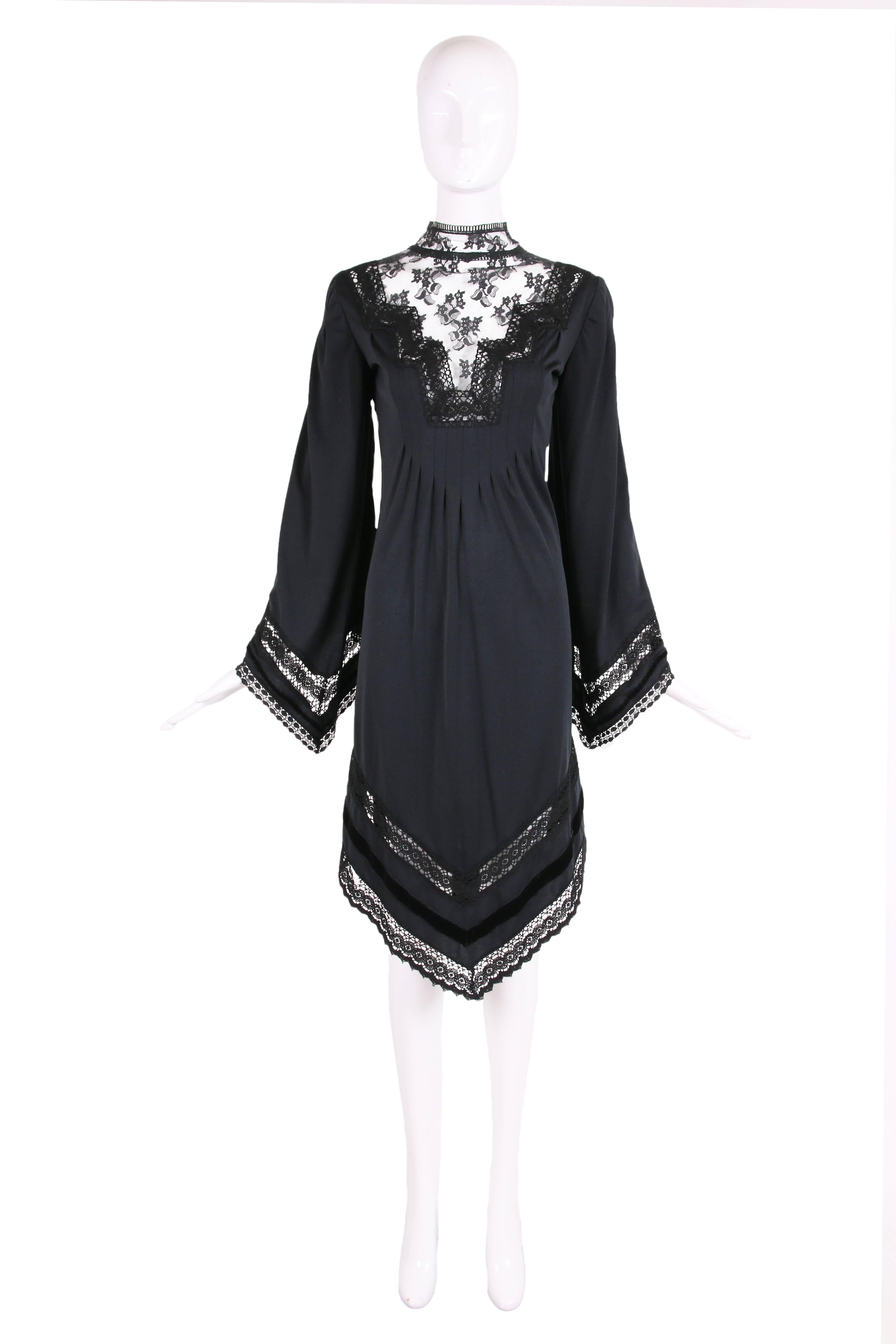 1970's Giorgio di Sant'Angelo black jersey dress with triangular hem at front and back. There is lace and crochet at the neckline and then lace, crochet and velvet trim in bands at the bell sleeves and hemline. In excellent condition with one very