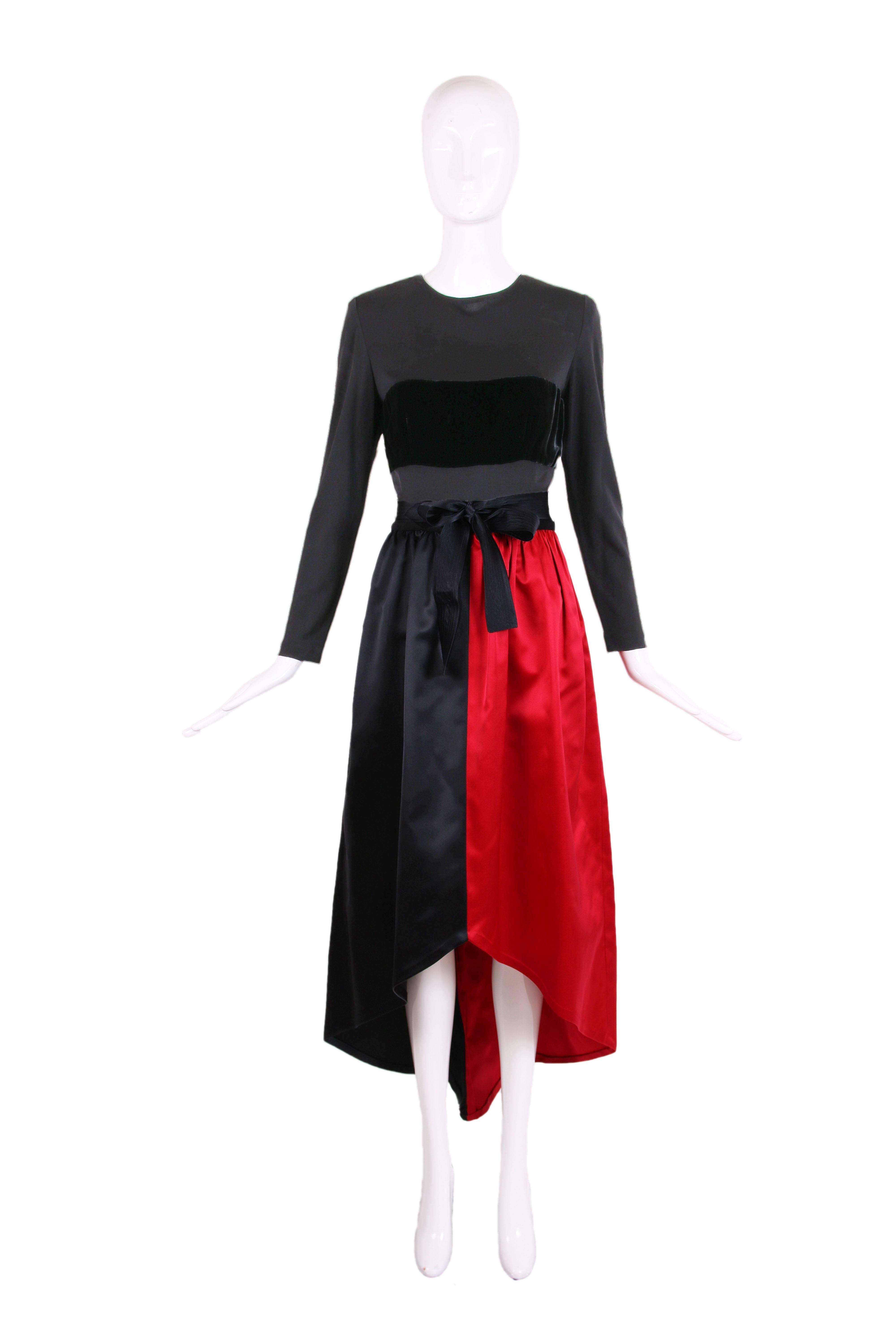 Vintage Bill Blass evening gown with black long sleeved illusion bodice, black velvet modesty band at bust and a skirt divided evenly down the middle into red and black satin panels. Comes with black satin belt that is 1.5