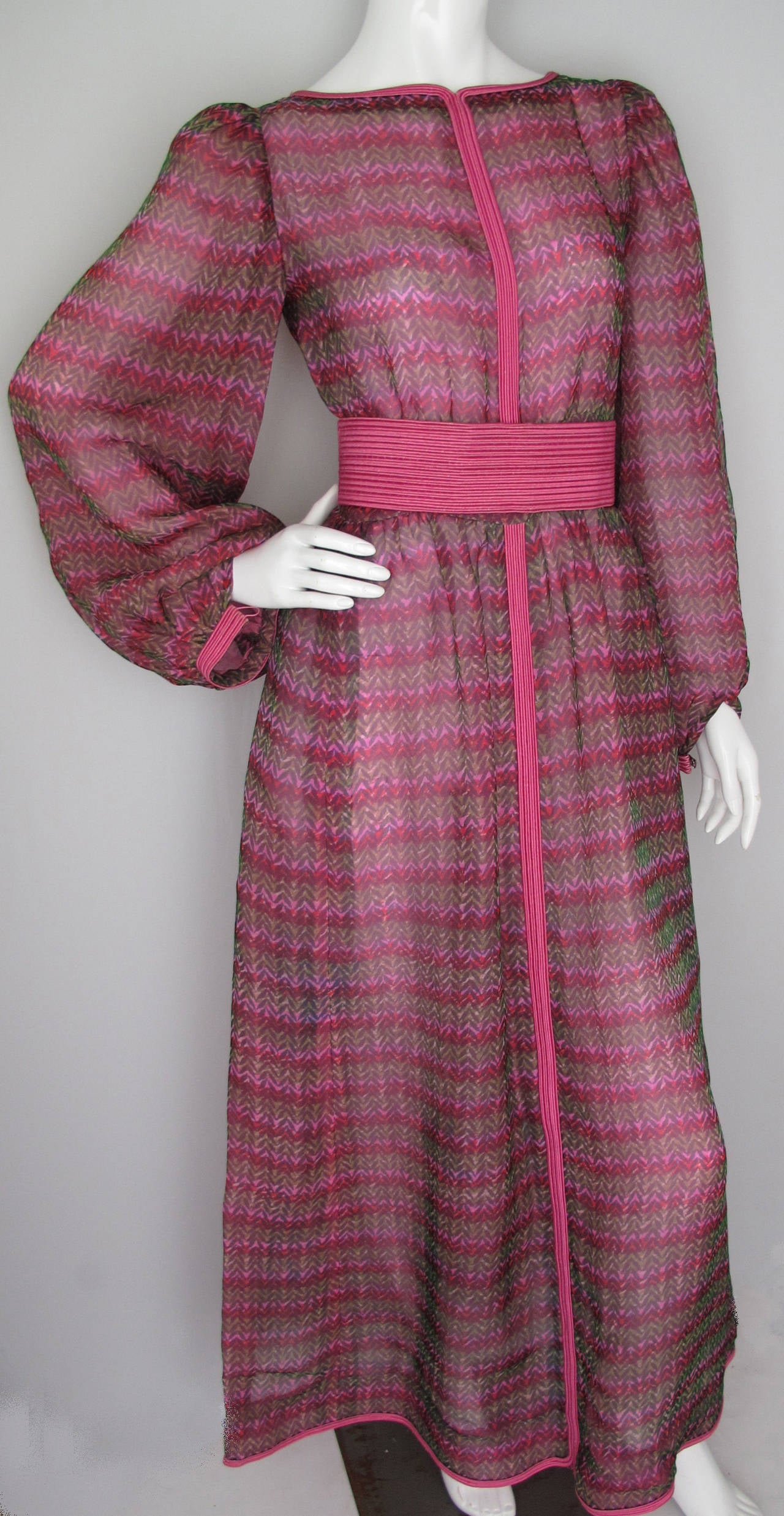 A 1970s Givenchy haute couture gown with full sleeves in shades of cranberry pink, mauve and green, with silk trim and two interchangeable belts. Since there is no fabric tag, my guess is the fabric is either a rayon or nylon organza and the lining
