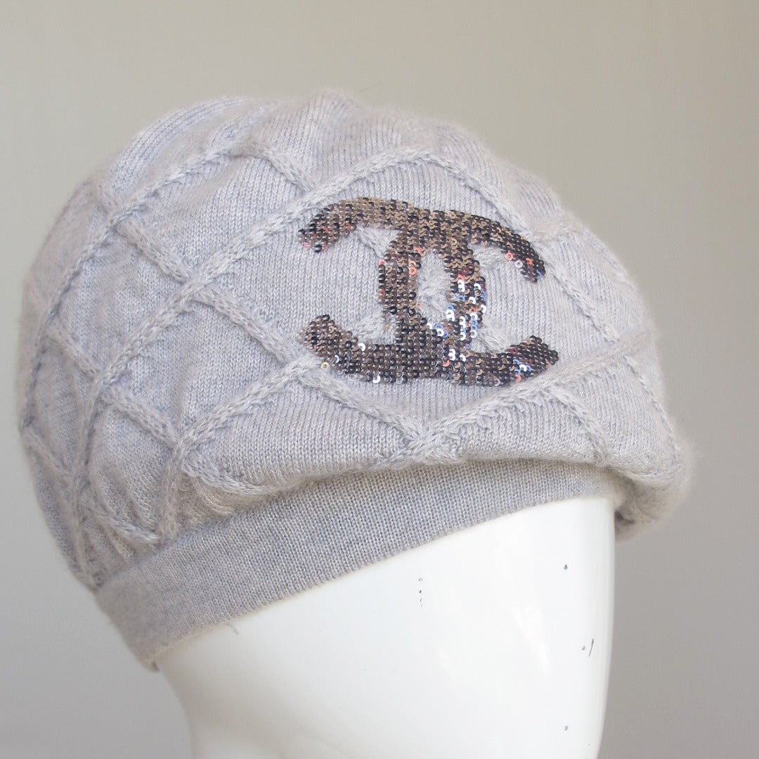 A Chanel 100% cashmere heather gray beret/hat with a repeated pattern of raised, knitted lattice design and the Chanel CC logo embroidered in mini-gray sequins. The cashmere is incredibly soft, stretchy and the knit is quite small. The hat can be