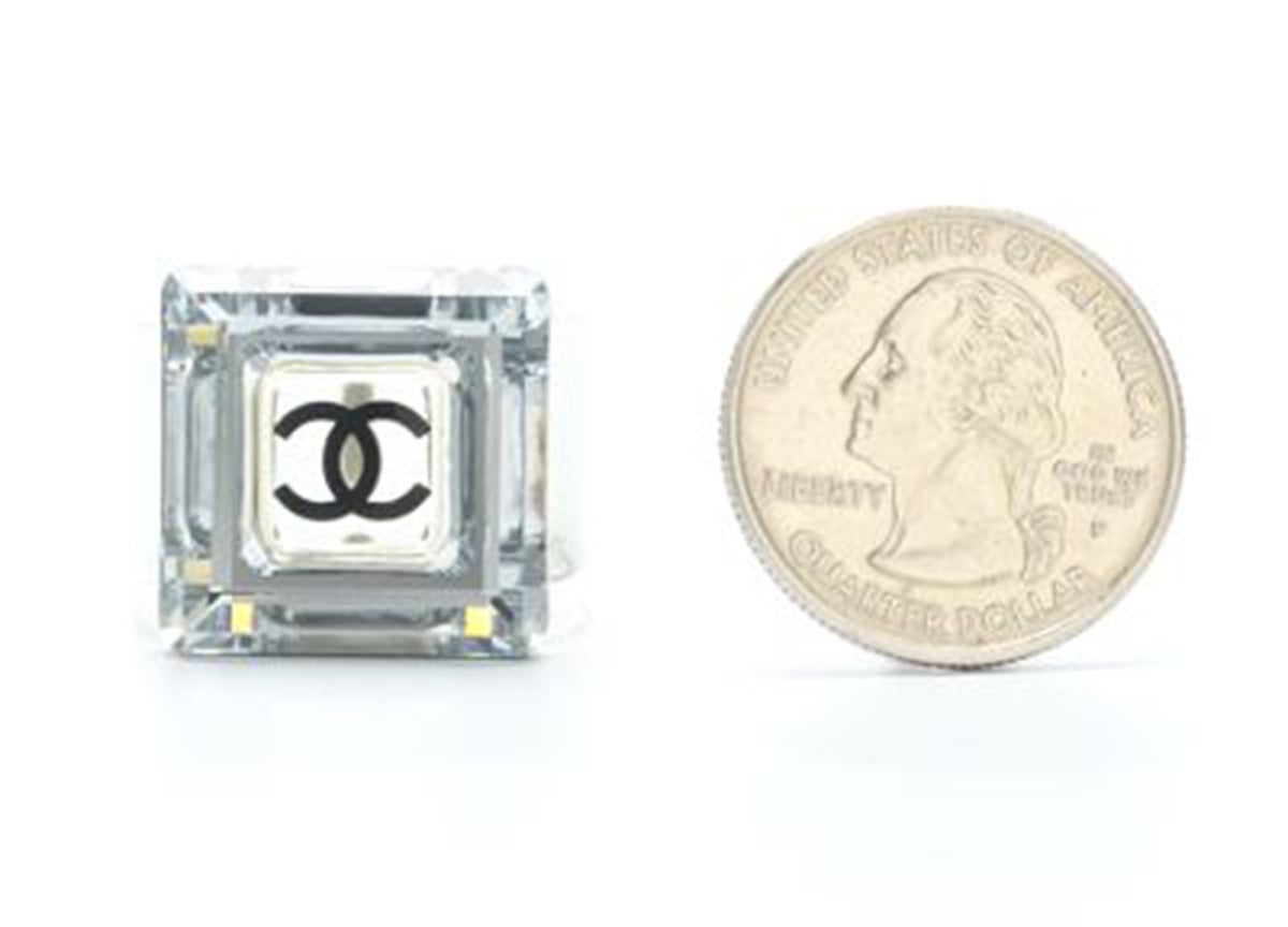 A 2005A Chanel clear acrylic cocktail ring with wide band set with an oversized square, edge-faceted crystal and Chanel CC logo at the center. The foil-backed crystal with its sparkling 