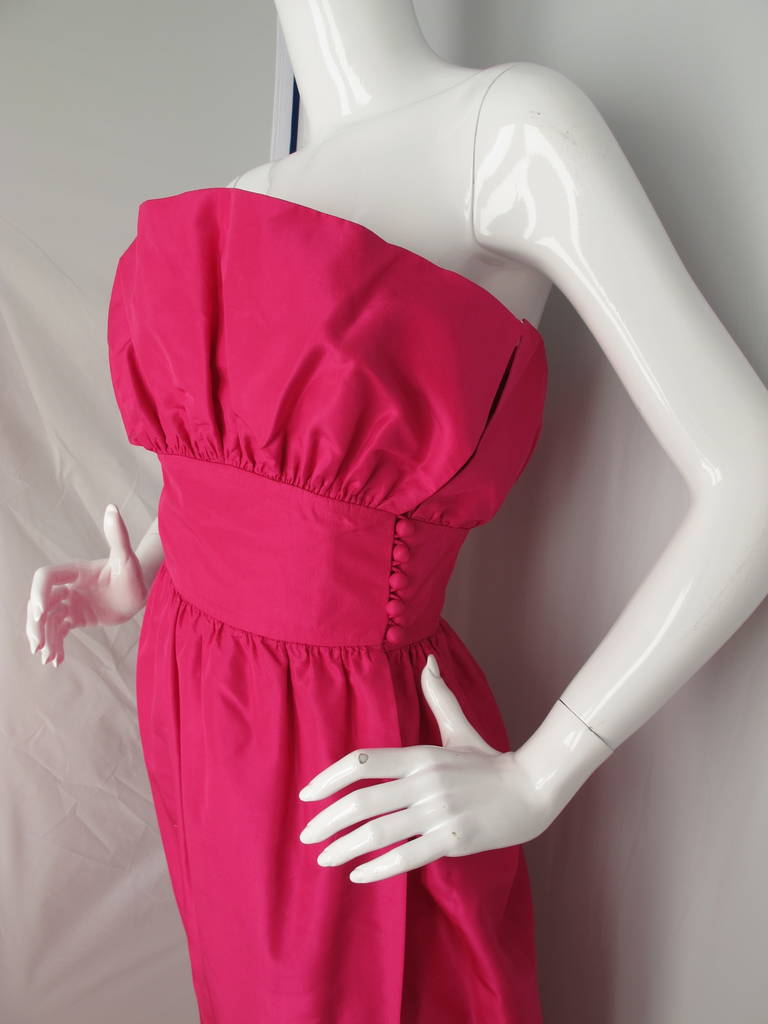 Circa 1970 Lanvin haute couture silk taffeta fuchsia formal gown with a petal-like design at the bodice. The dress is constructed from a wrap around skirt and fastens via fabric-covered buttons that run up the left side beginning at the waist. The