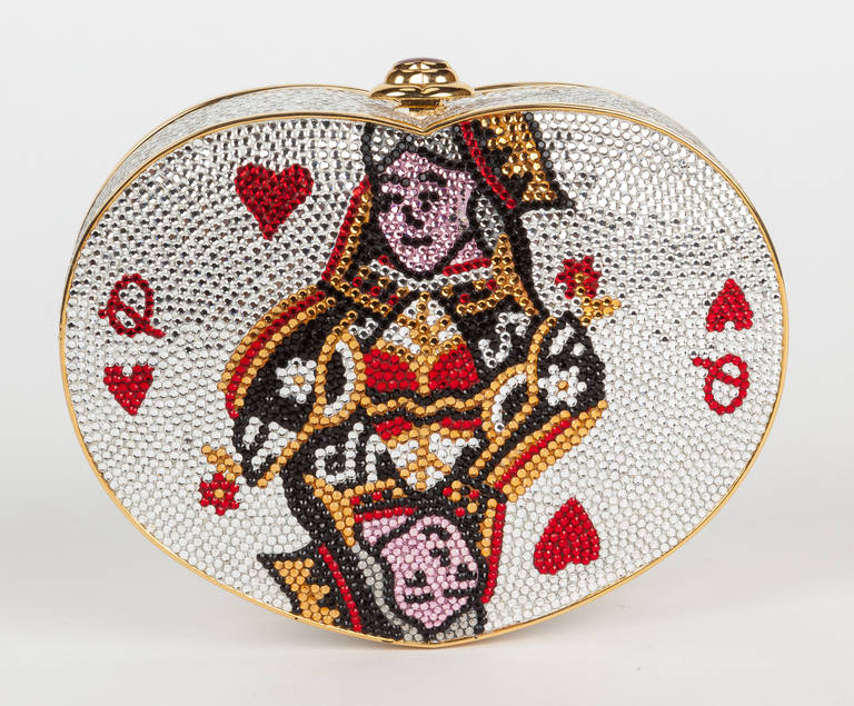 The iconic Judith Leiber Queen of Hearts minaudière is one of the most sought after and collectable of all Judith Leiber designs. This heart-shaped minaudière is fully beaded with silver crystals and the Queen of Hearts designed from red, gold, and