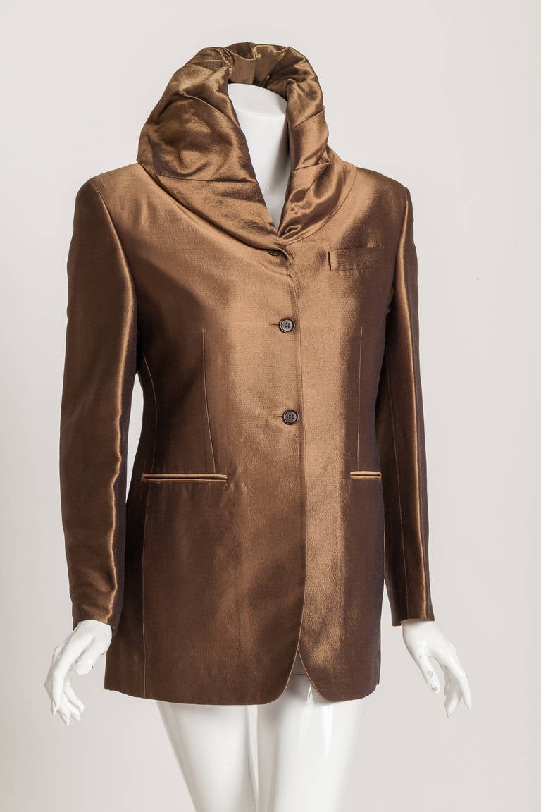 From Romeo Gigli, the "designer's designer" is this iconic hooded jacket in shiny bronze from one of his last collections - part of the permanent collection of the MET. Fully lined at the interior, interior pocket and two vent slits at the