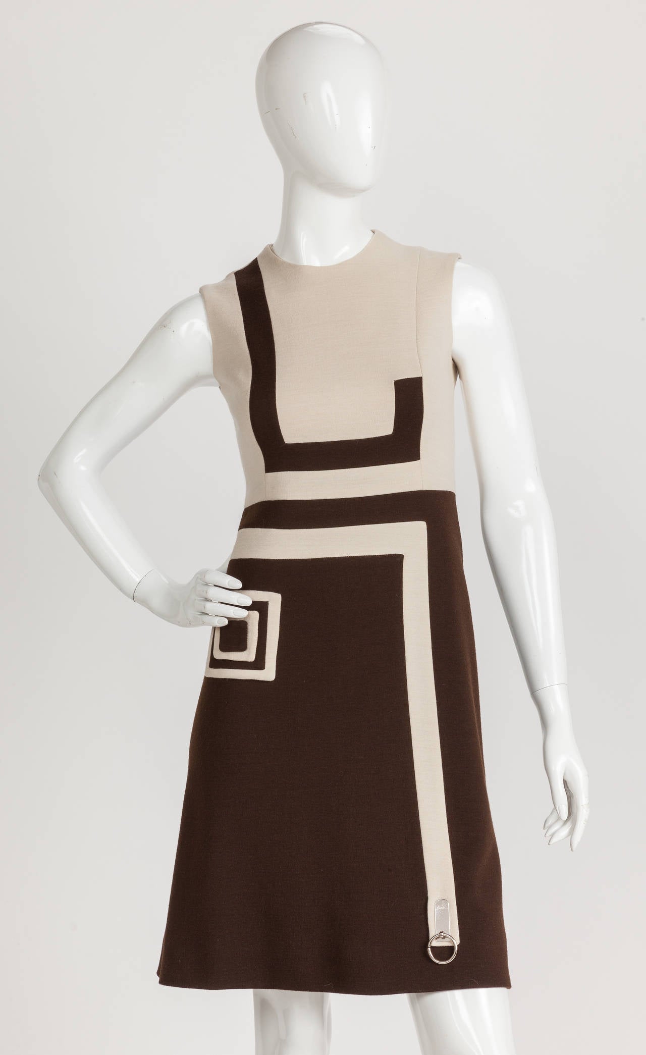 A Pierre Cardin sleeveless wool jersey dress in creme and brown with graphic print design. I'm such a fan of this hip and sophisticated mod day dress with its flared skirt and modern decorative elements: a square inside a square appliquéd at the