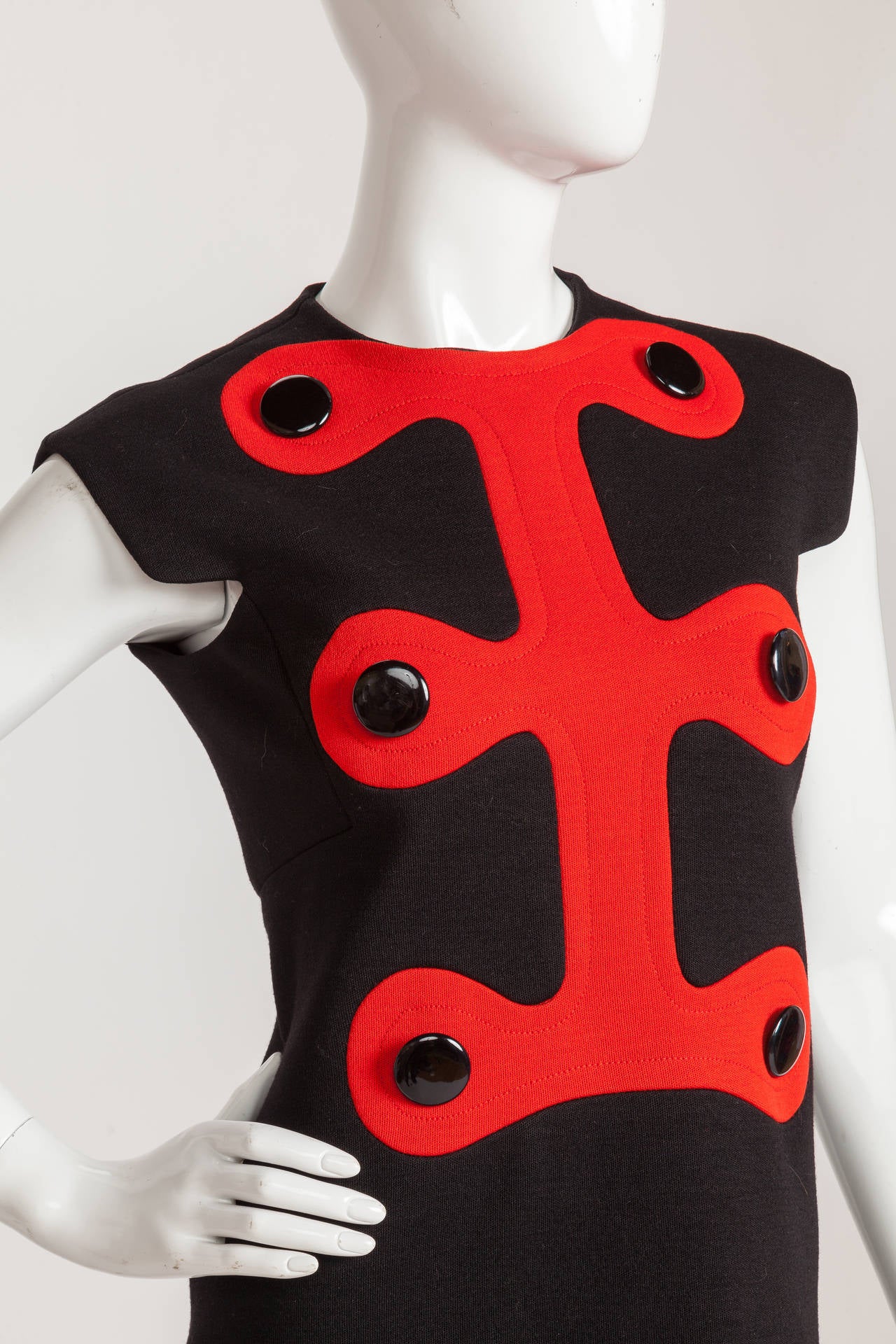 Iconic 1972 Pierre Cardin black wool jersey day dress with red abstract motif, oversized black buttons and square shoulders with notched arm holes. Fully lined at the interior and zips up the back. No size tag so please consult measurements. My