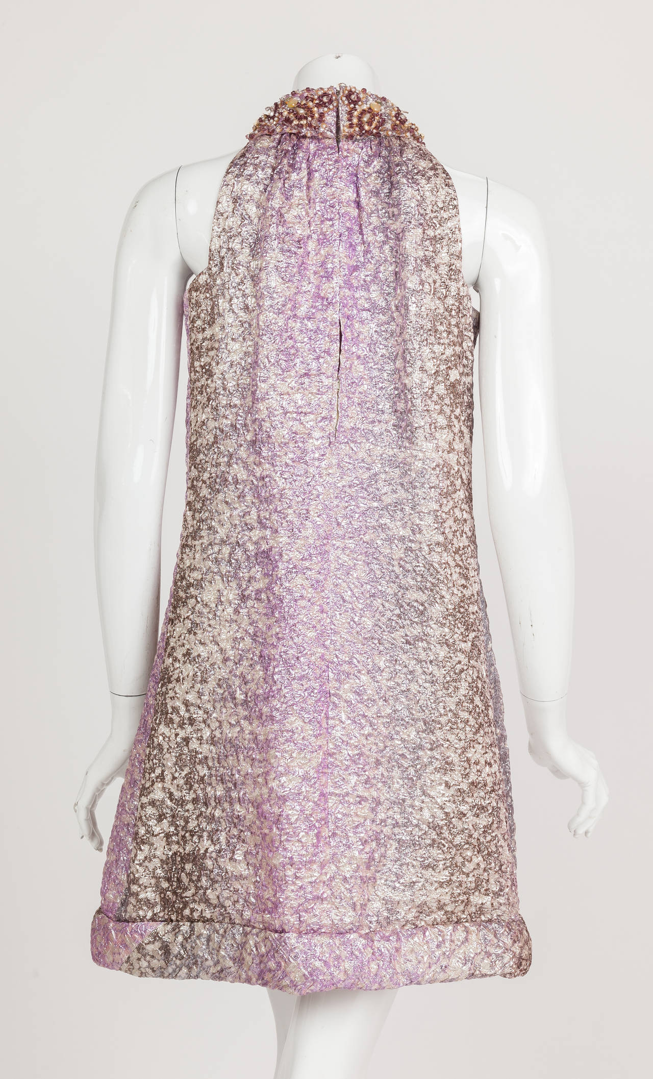 A circa 1966 Pierre Cardin haute couture cocktail dress in purple, silver and pink ombre lame with beading at the collar and the classic Cardin keyhole opening at the back below the neck. I love this sexy yet chic dress and its treatment of the 