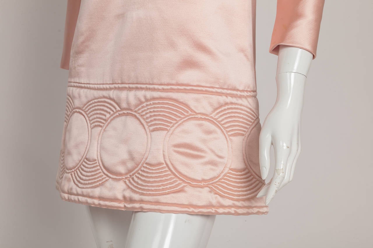 This luxurious 1969 pink satin shift mini-dress is a masterful example of Pierre Cardin’s “Space Age” creations. With its recti-linear shape that stands away from the body, Cardin freed the modern woman from the constraints of figure-confining
