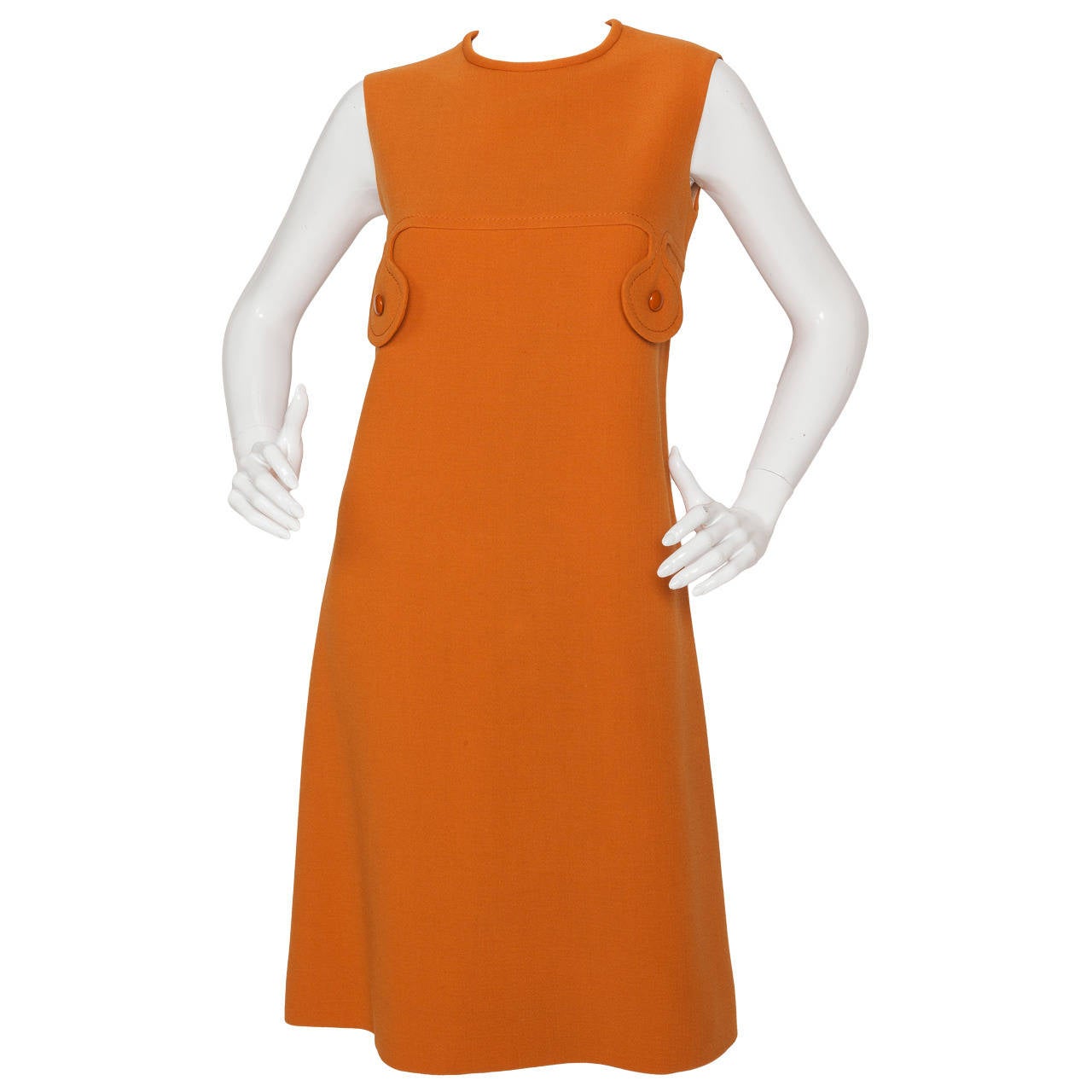 A circa 1971 Pierre Cardin pumpkin-colored wool crepe sleeveless sheath dress with matching fitted jacket that features oversized orange matching shiny buttons and a petalled jacket collar and lapel. Lined with 