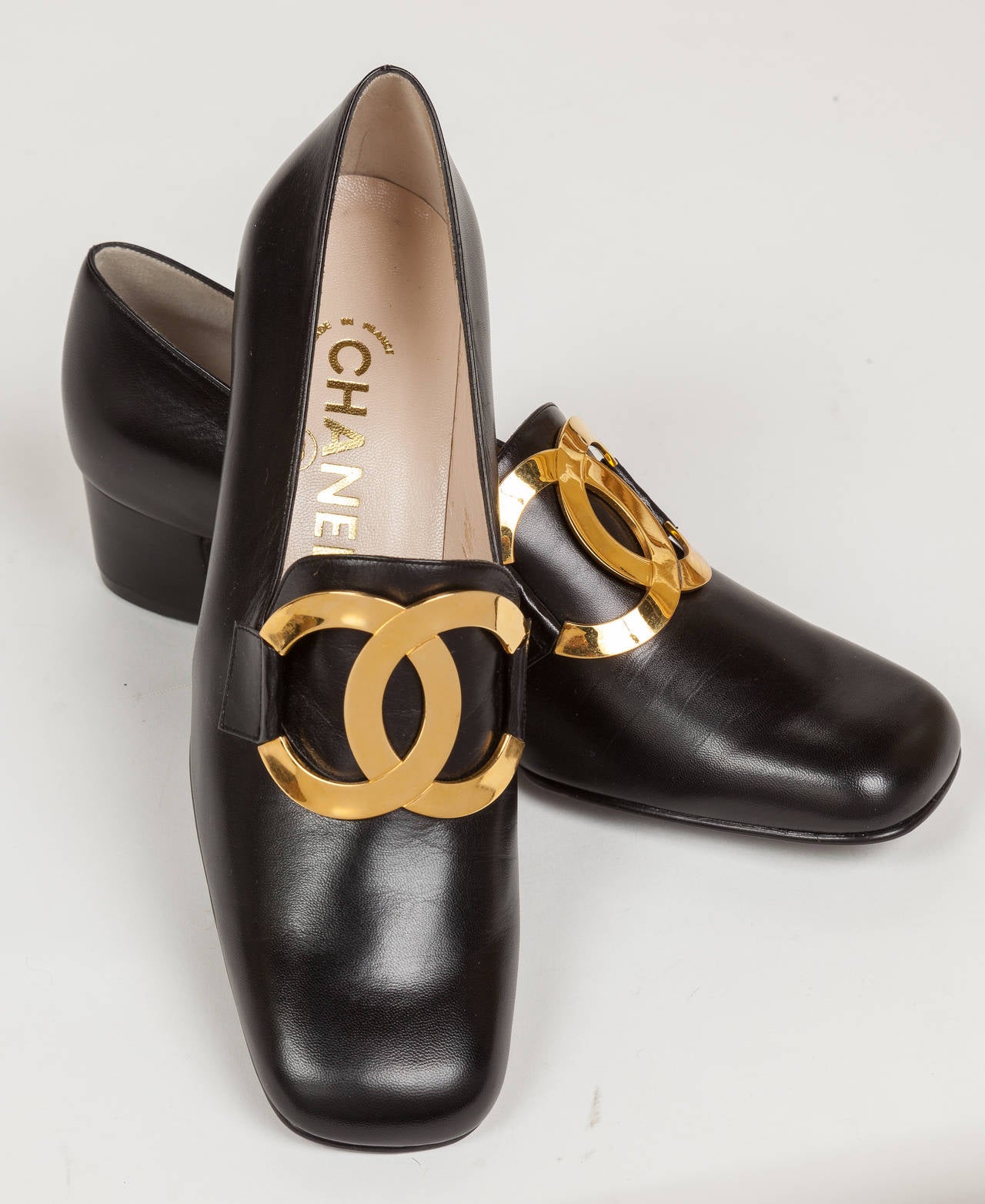 A pair of 1996 Chanel never-been-worn black kid leather loafers with oversized CC gold tone metal logo. They are marked size 37 1/2 B which translates to approximately a women's size 7. in excellent condition without any scratches or scuffs to the