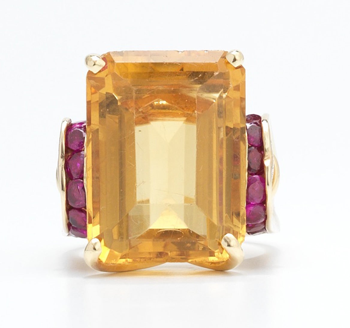 18k yellow gold cocktail ring set with an emerald cut citrine, measuring 19mm x 13.9mm x 9.5mm, and further accented with channel set round cut rubies; overall weight 11.4 gm. Ring size 5 1/2
Condition: Rubies possibly synthetic. Minor surface