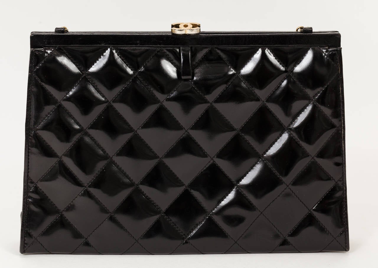 1970's Chanel slim patent leather quilted handbag with gold tone CC logo clasp at the top edge and a long chain strap which attaches at the interior side wall and allows for an easy conversion to a clutch. The interior is lined with leather and