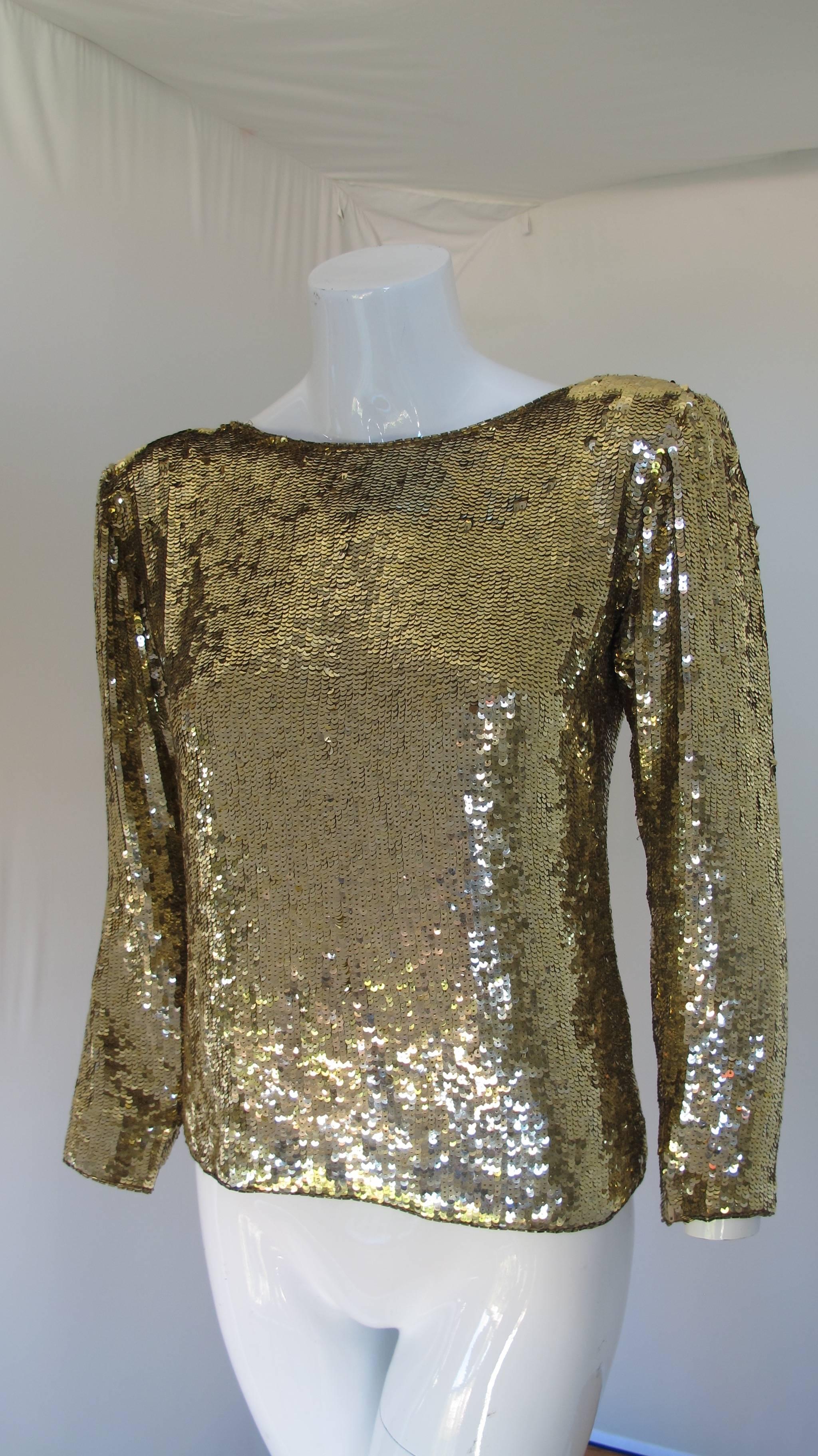 Yves Saint Laurent gold sequin blouse with a deep V-neck at the back and oversized buttons with rhinestones. The top neckline is embellished with gold bugle beads. Most likely dating from the late 1970's. Fully lined in silk, size tag S. In very