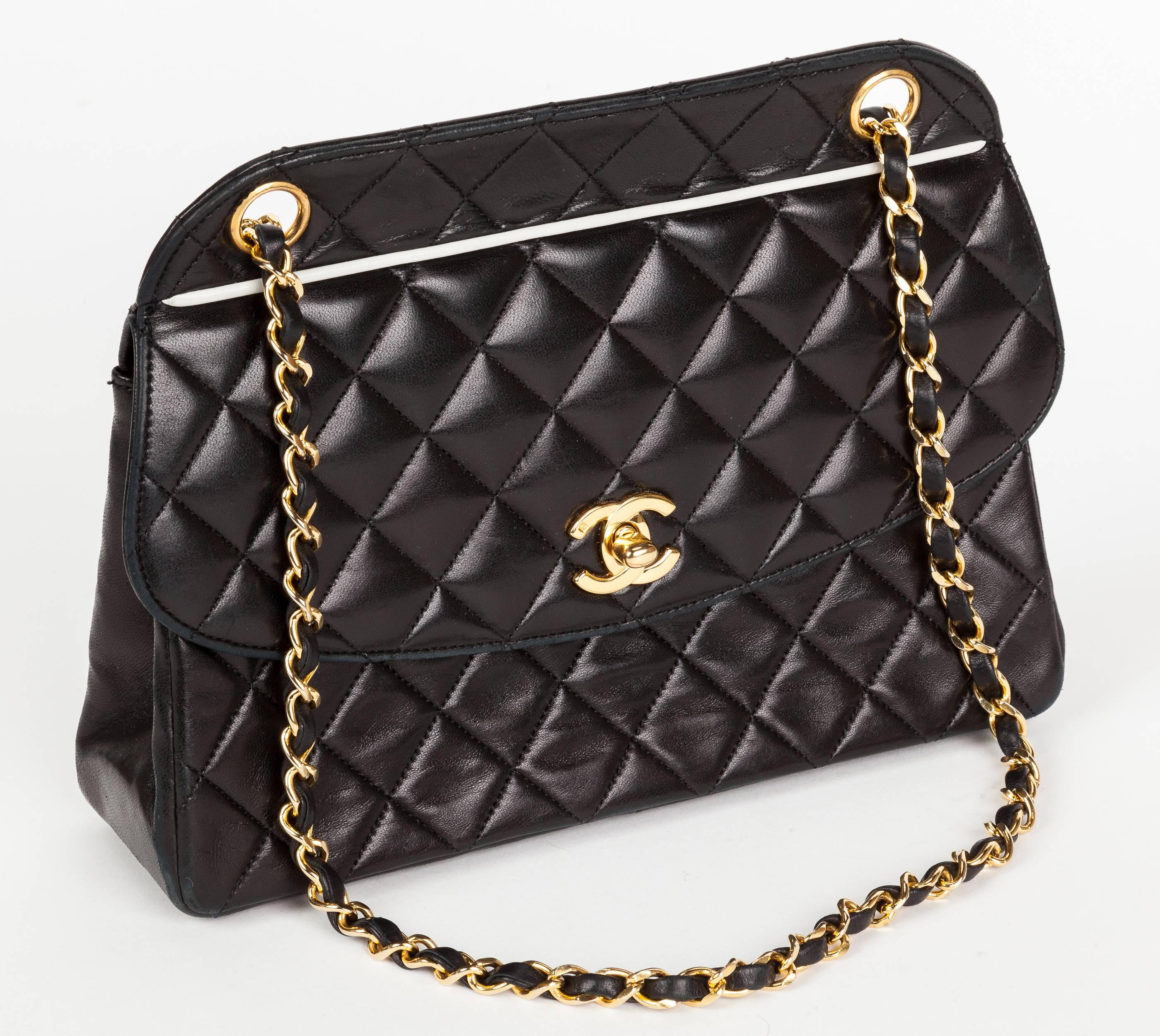 A 1991 Chanel quilted soft calfskin leather handbag with double chain shoulder strap, gold tone hardware, turn lock fastener and white leather trim both at front and back exterior pocket edge. Opens to one main compartment with side pocket. Stamped