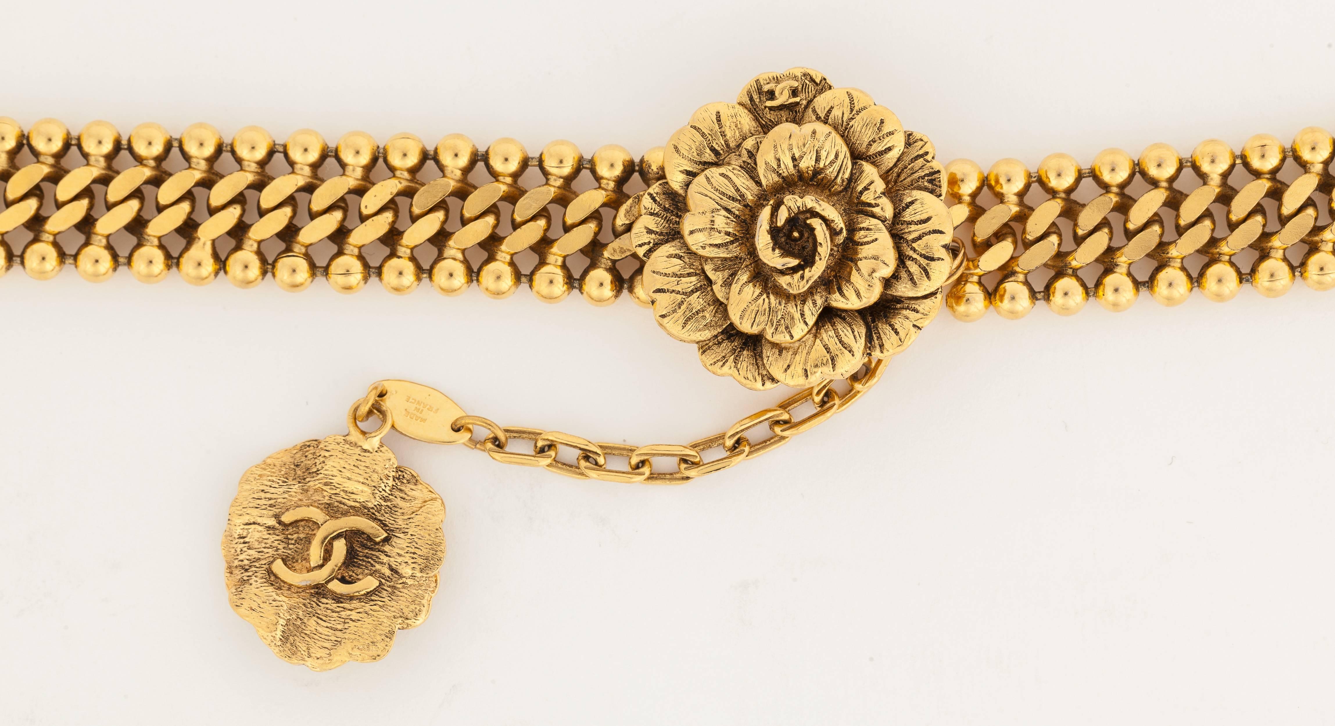 A 1983 Chanel gold tone metal chain belt with flower buckle and hook fastener. There is a flower charm with CC logo on the underside hanging off the chain that fastens to the buckle. In excellent condition. Stamped: Chanel
MEASUREMENTS:
Length -