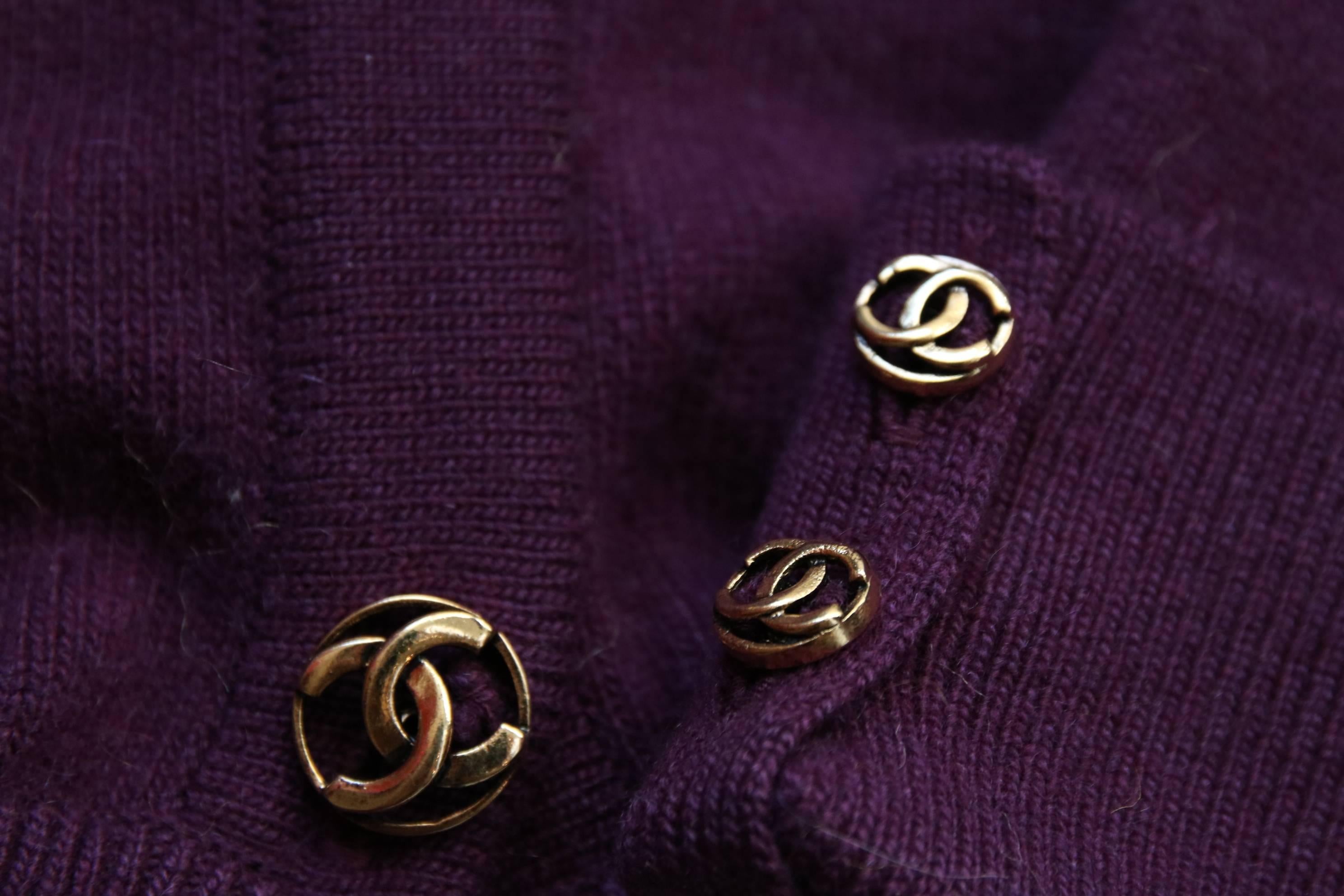 A vintage Chanel plum/purple 100% cashmere cardigan sweater featuring two in-built waist ties in a slightly cropped length. Features Chanel CC logo buttons down center front and sleeve cuffs. In excellent condition. Size tag: