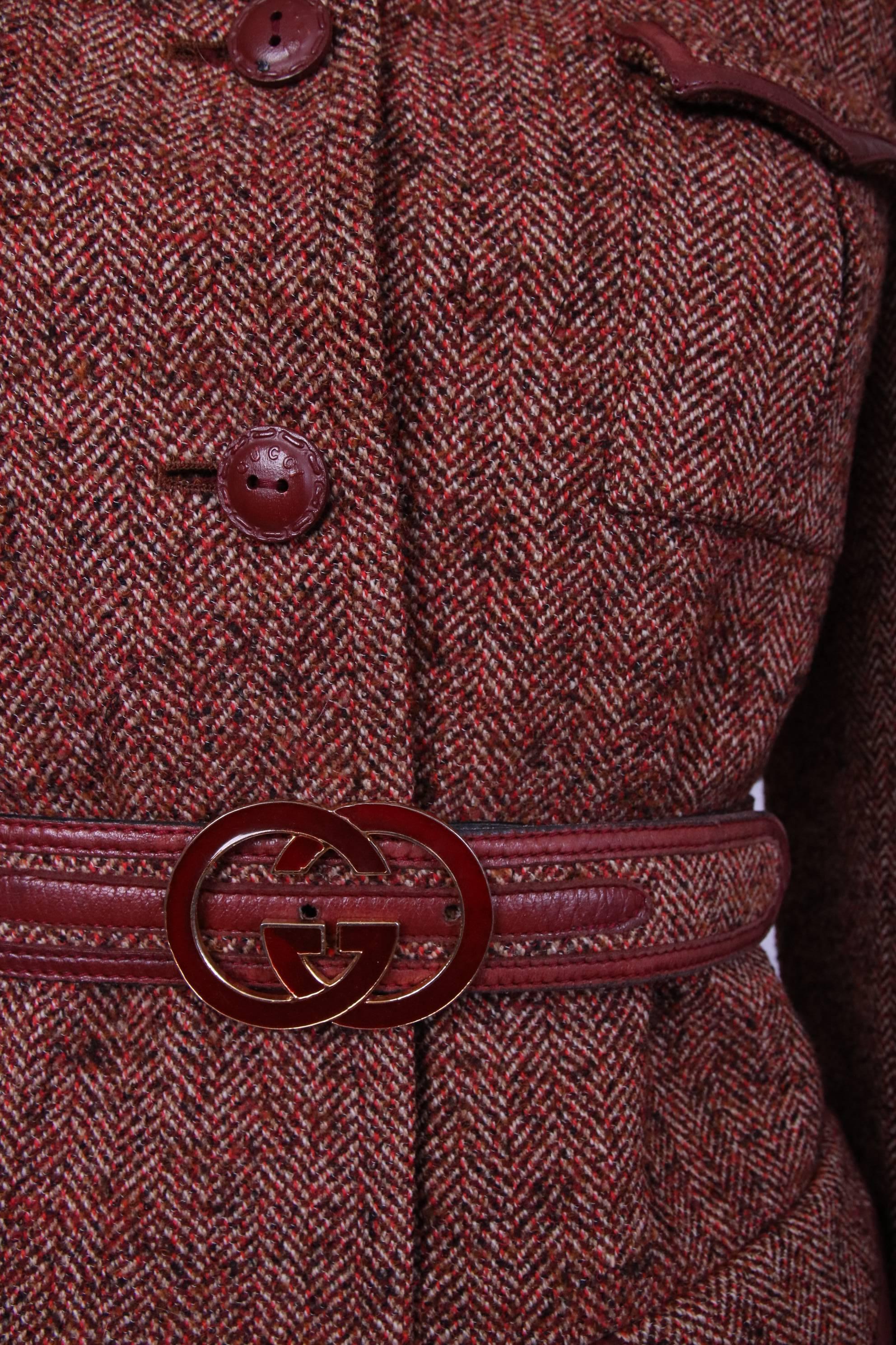 1970's Gucci tweed jacket with enameled burgundy color Gucci GG logo belt buckle, brown leather buttons and trim at pockets and sleeves. Entirely lined with at the interior with Gucci logo fabric. In excellent condition. Size 42. Please consult