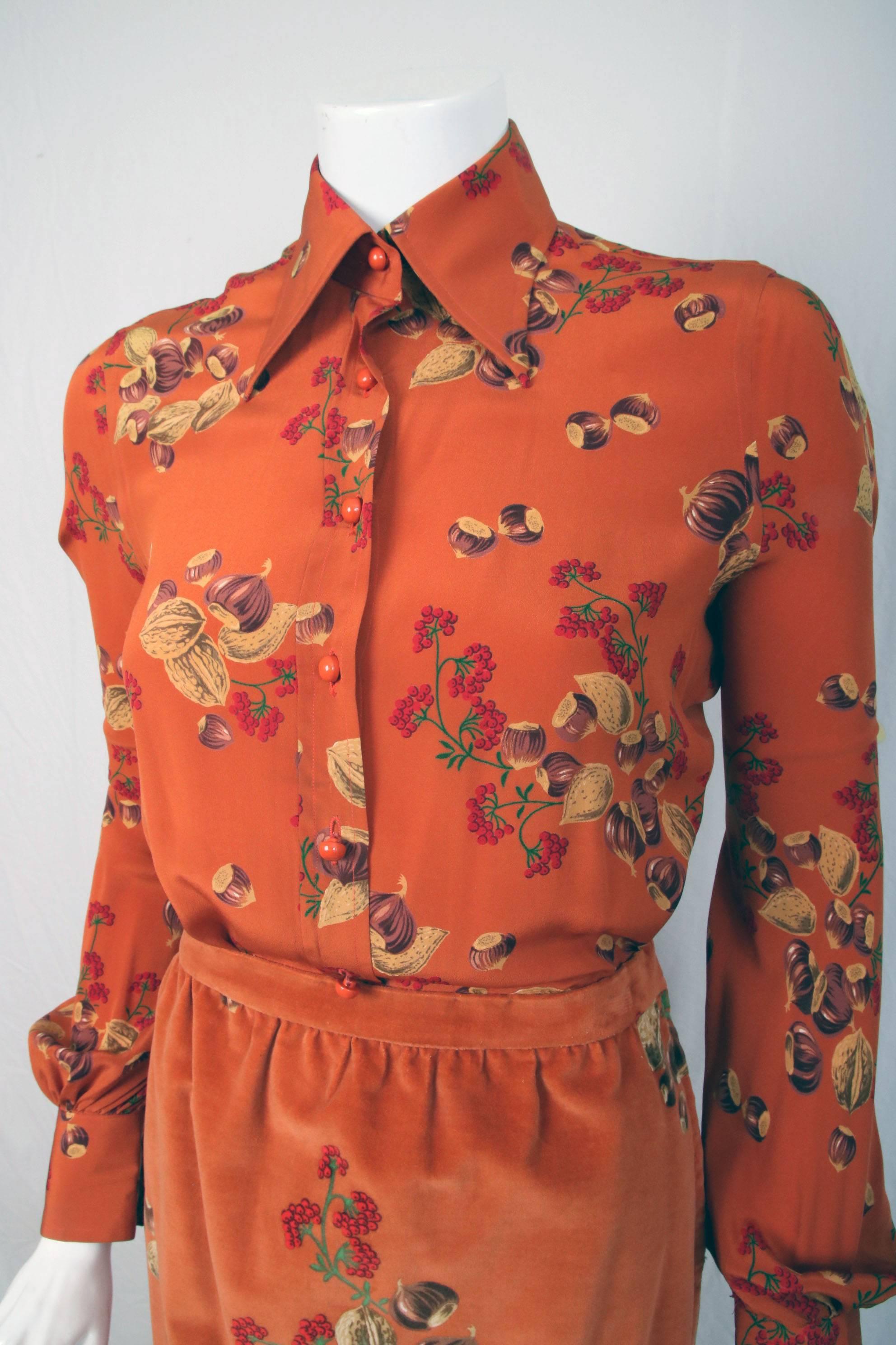1970's Valentino iconic and rare "acorn print" ensemble comprised of a velvet maxi skirt and 100% silk button up blouse in burnt orange. The skirt has a zip and hook closure. This set is complete with head scarf done in the same print. In