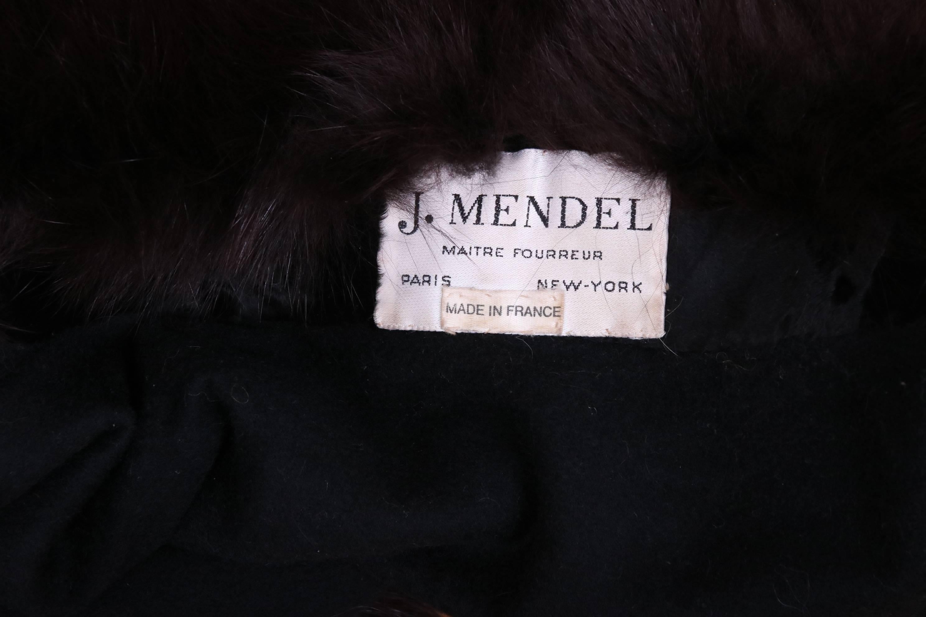 This historical and rare, circa 1983 J. Mendel black astrakhan cape was one of the first garments designed by Mendel upon becoming the designer and CEO of his family-owned business. Trimmed in black fox fur, the one-armed cape has a wraparound