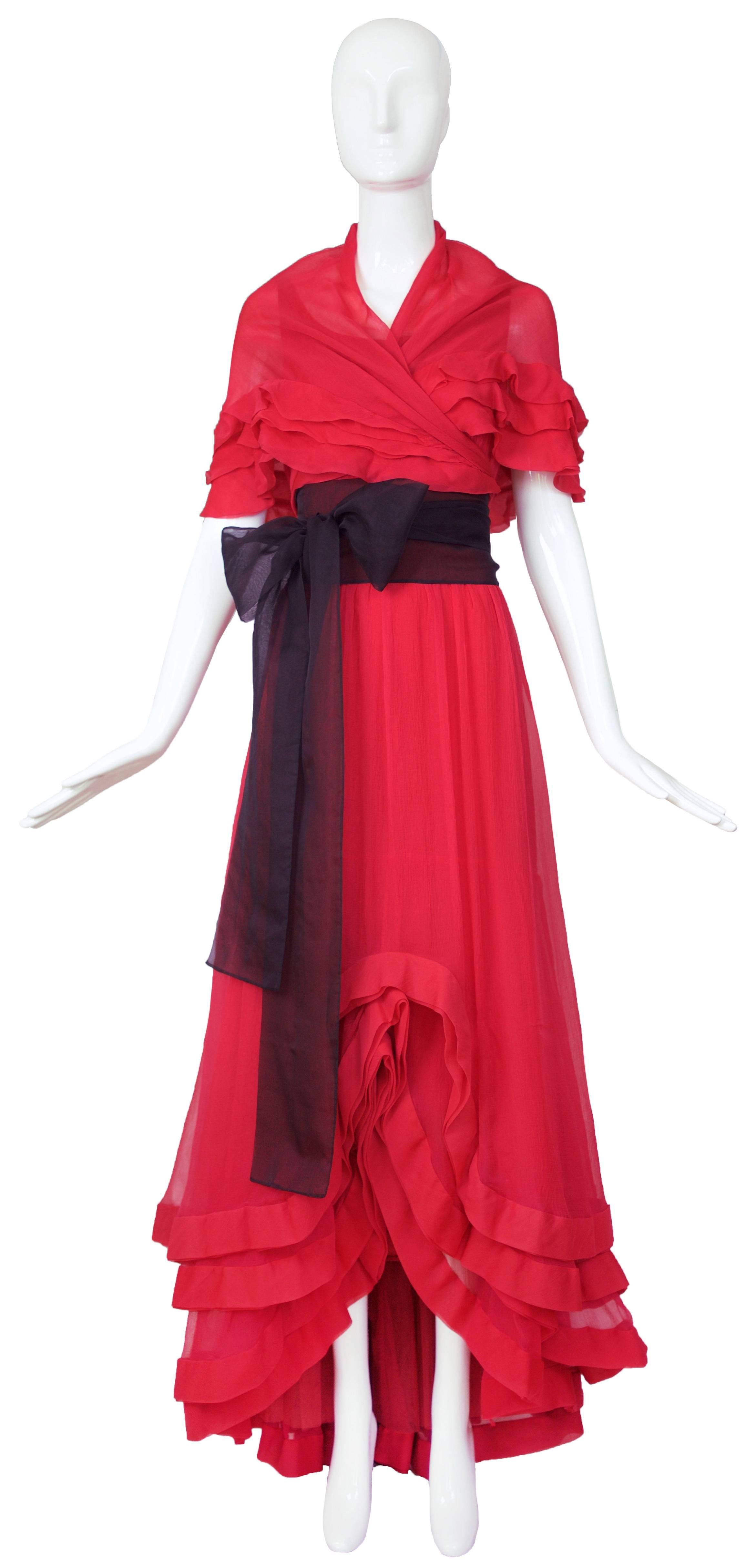 Circa 1968/1970's Valentino couture multi-layered chiffon and crepe gown in a deep red imbued with fuchsia undertones with a waterfall hem, crinoline at the interior of the back bottom hem and side zipper closure. Comes with a black chiffon sash and
