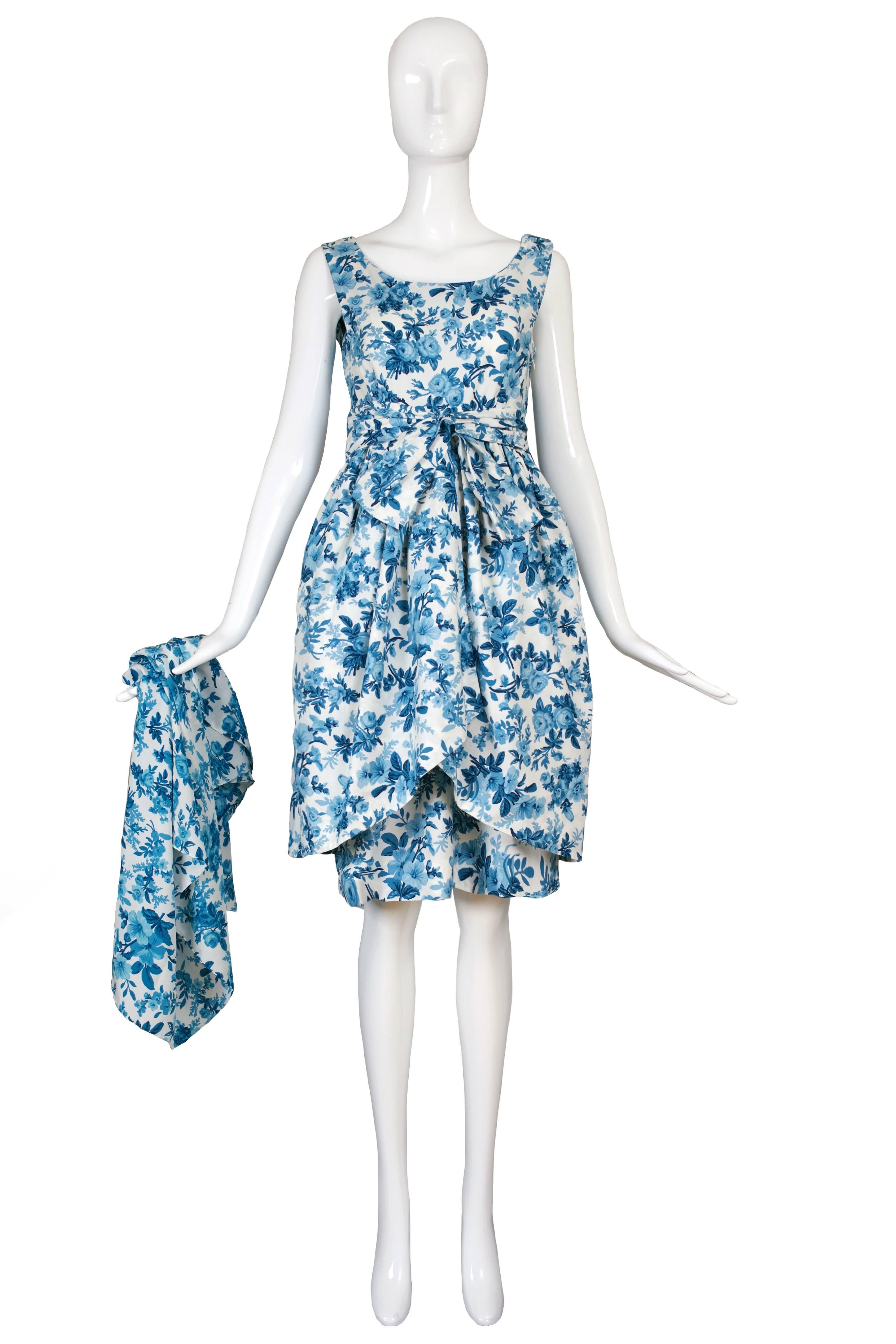 Balenciaga by Nicolas Ghesquiere cotton blue and white floral summer dress inspired by 1950's garden party. The dress has full skirt with peplum overlay and intricate hook and eye fasteners. There is a self sash belt & scarf to complete the look. In