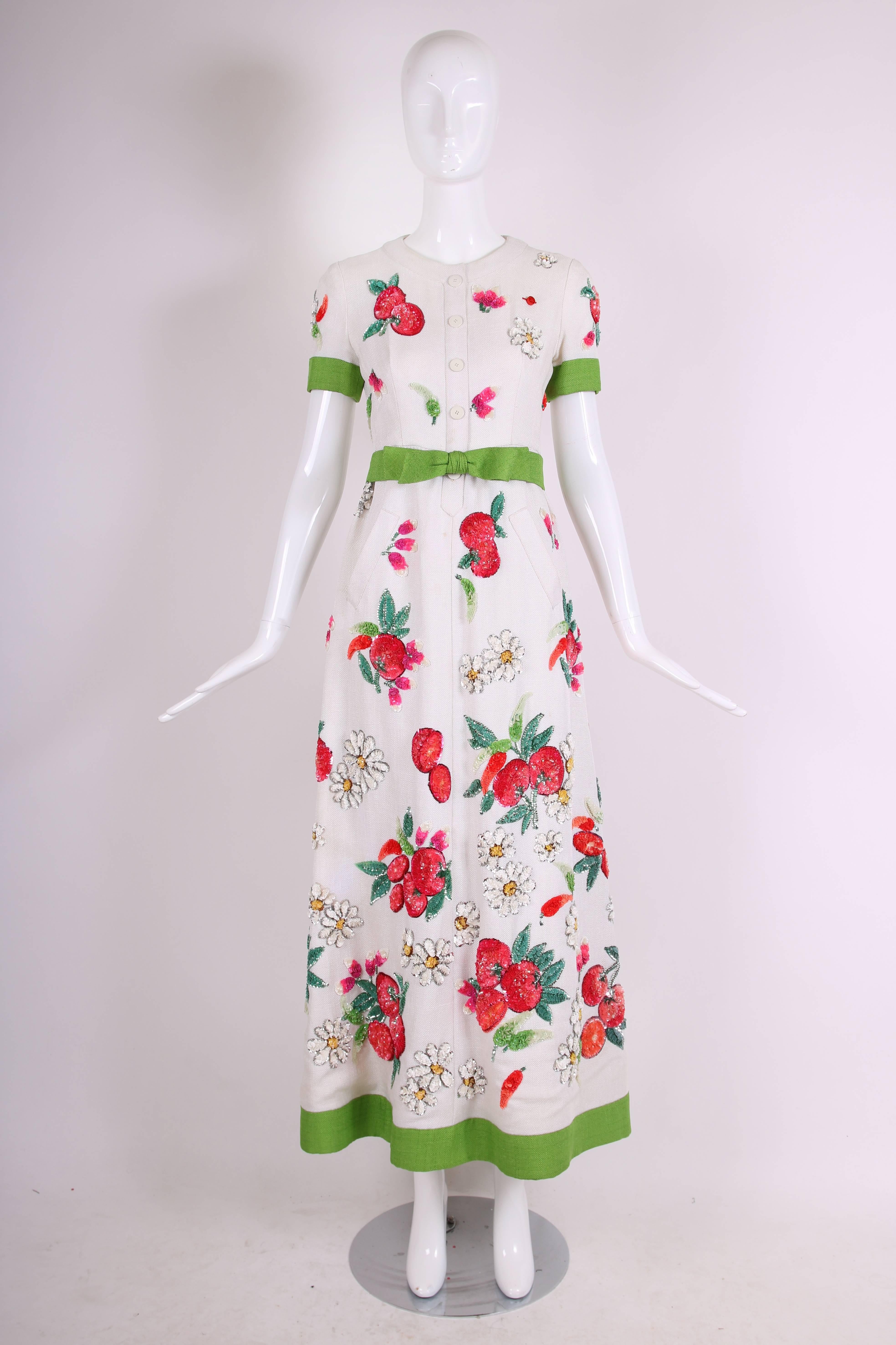 1960's Nina Ricci for Bergdorf Goodman heavy linen summer evening gown featuring clusters of sequined daisies and fruit. Entirely lined with silk taffeta and comes with a detachable green belt. In very good vintage condition with some missing