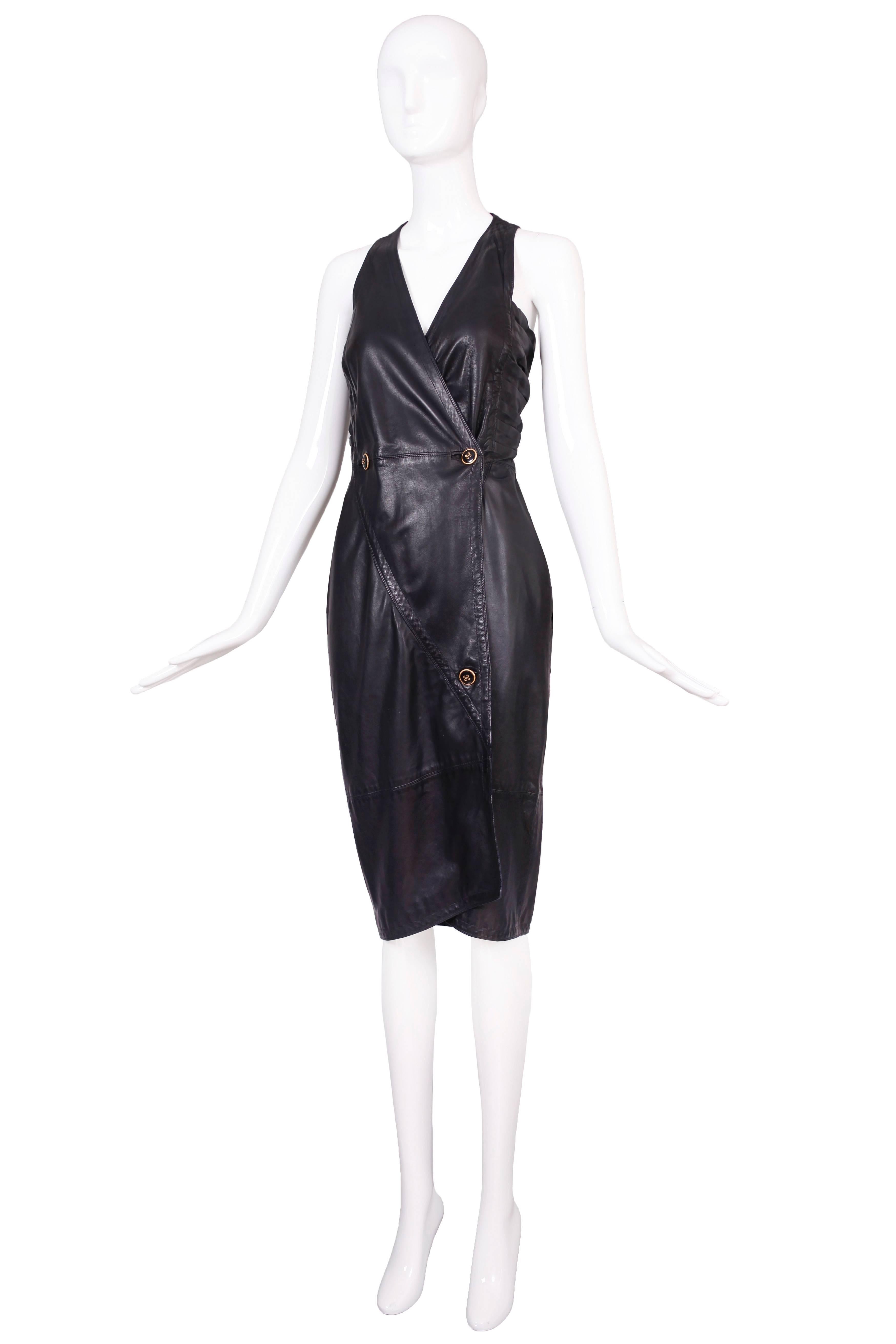 Circa 1986 Versace leather halter dress with wrap skirt and ruching at the sides. In excellent condition with some faint marks at the front skirt panel and one tiny area, hidden under the front skirt panel with a minor abrasion to the leather where