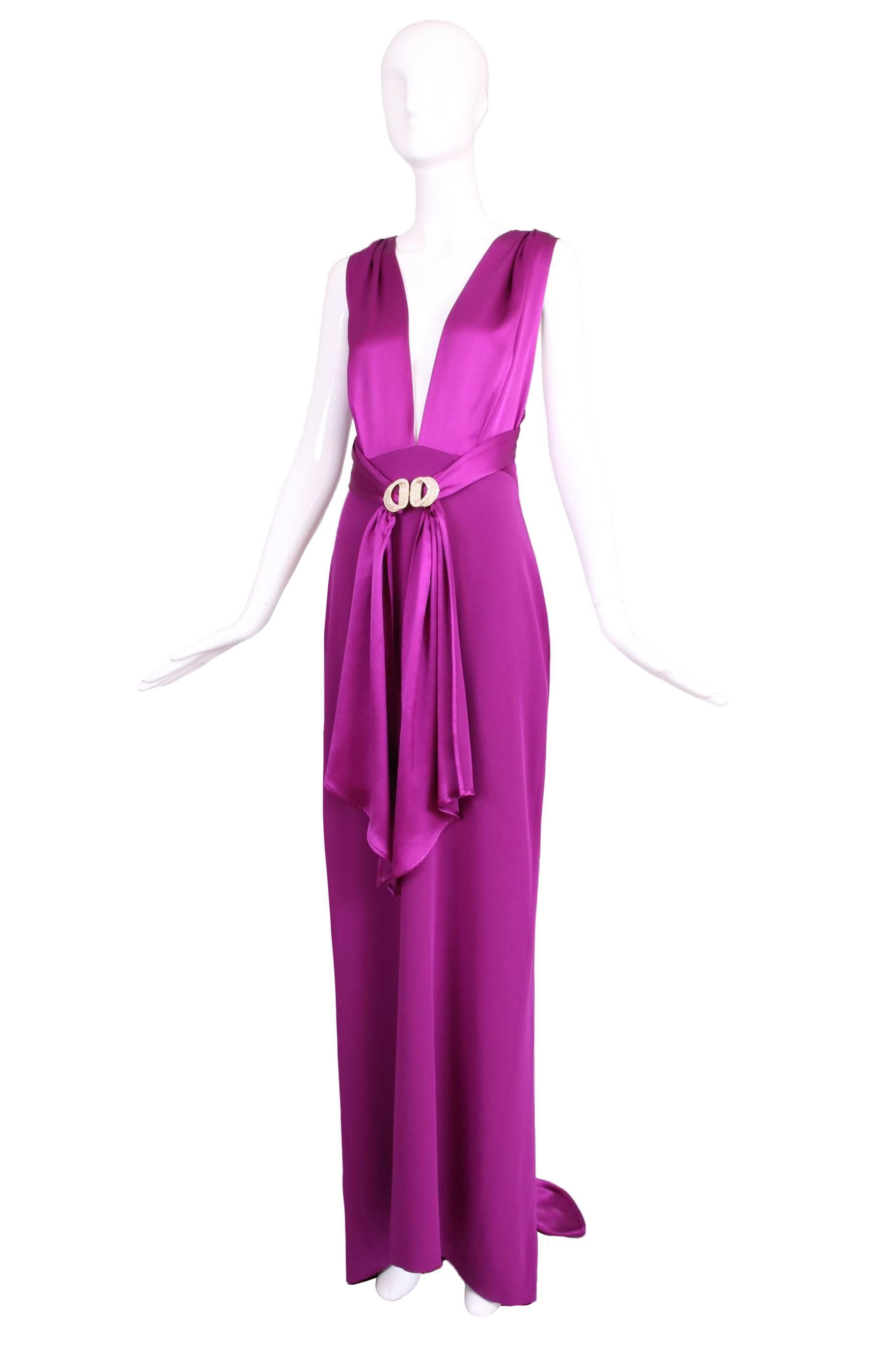 Dolce & Gabbana 100% silk fuchsia dramatic plunge neck evening gown with rhinestone buckle waist ties and silk satin mini train at the back. In excellent condition. Size tag 44.
MEASUREMENTS:
Waist - 28"
Hips - 40"