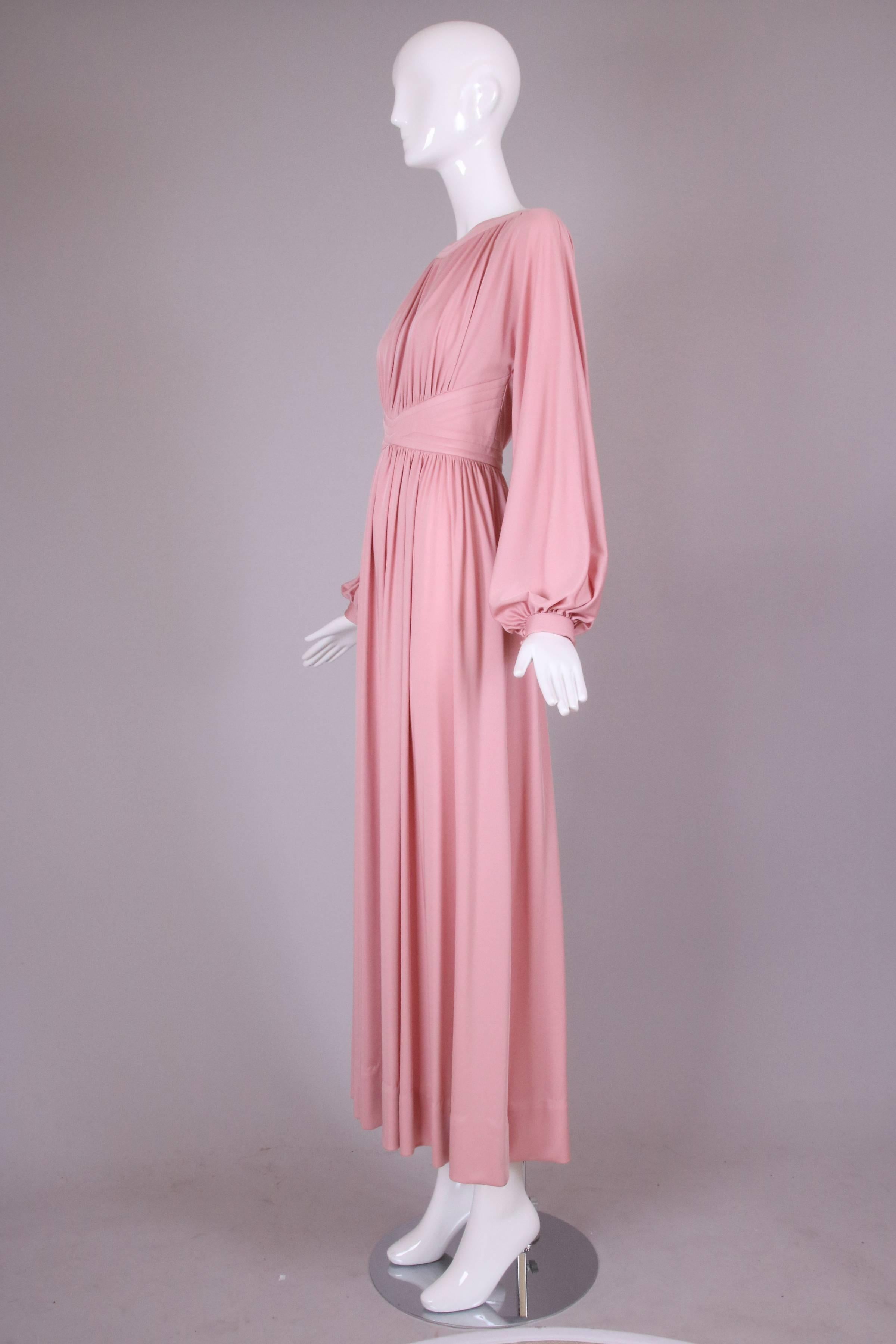 Donald Brooks rose pink jersey maxi dress with balloon sleeves. There is decorative top stitching at the waist band and neckline and high cut dolman armholes. The dress has  a zipper closure  at the back center and covered buttons at neck and waist.
