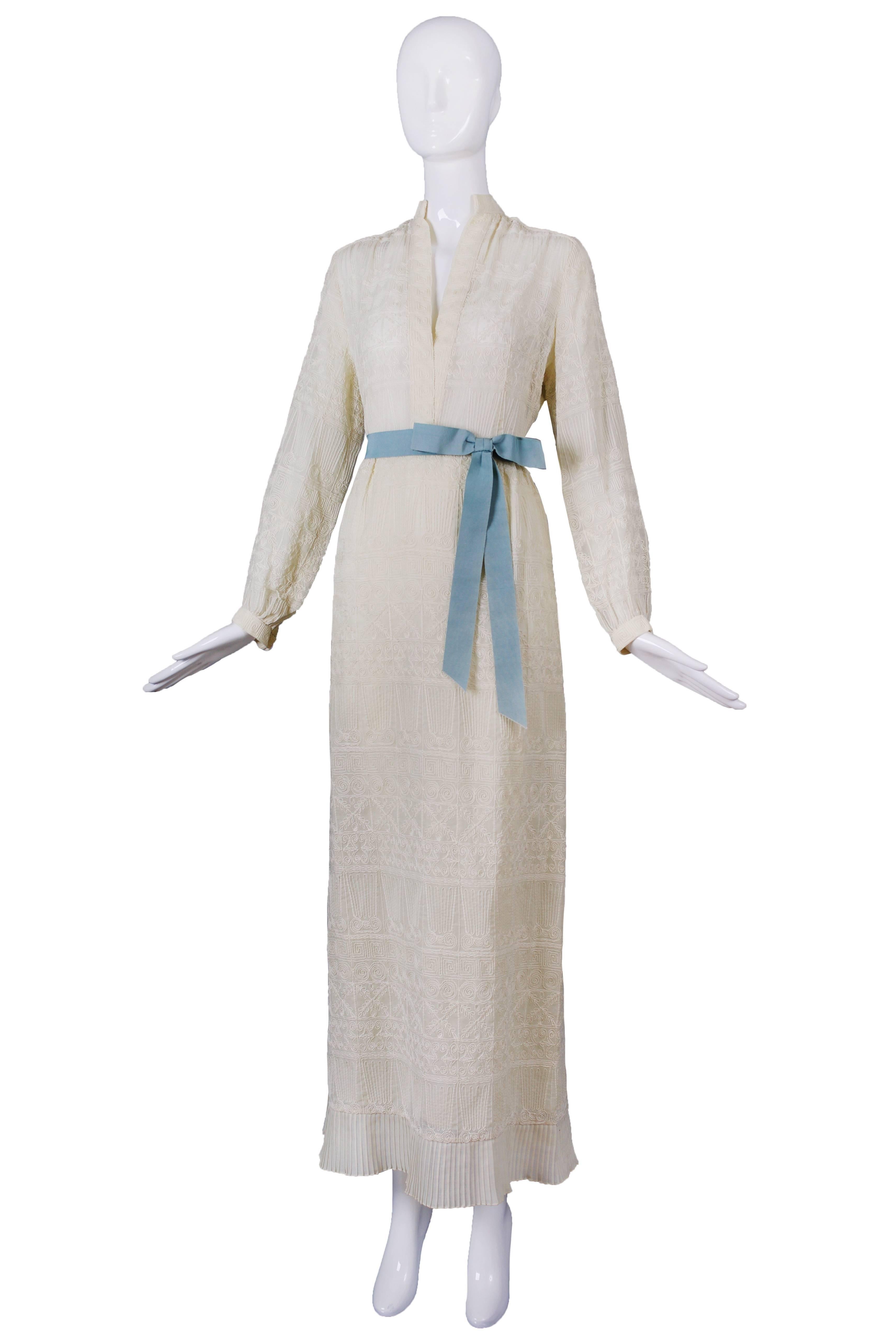 A 1970s Pat Sandler tea or wedding gown in a soft off white/creme-colored hue and embroidered from head to toe, giving the illusion of lace. There is no size or fabric tag but I'm guessing the fabric is either cotton or a cotton blend. Please