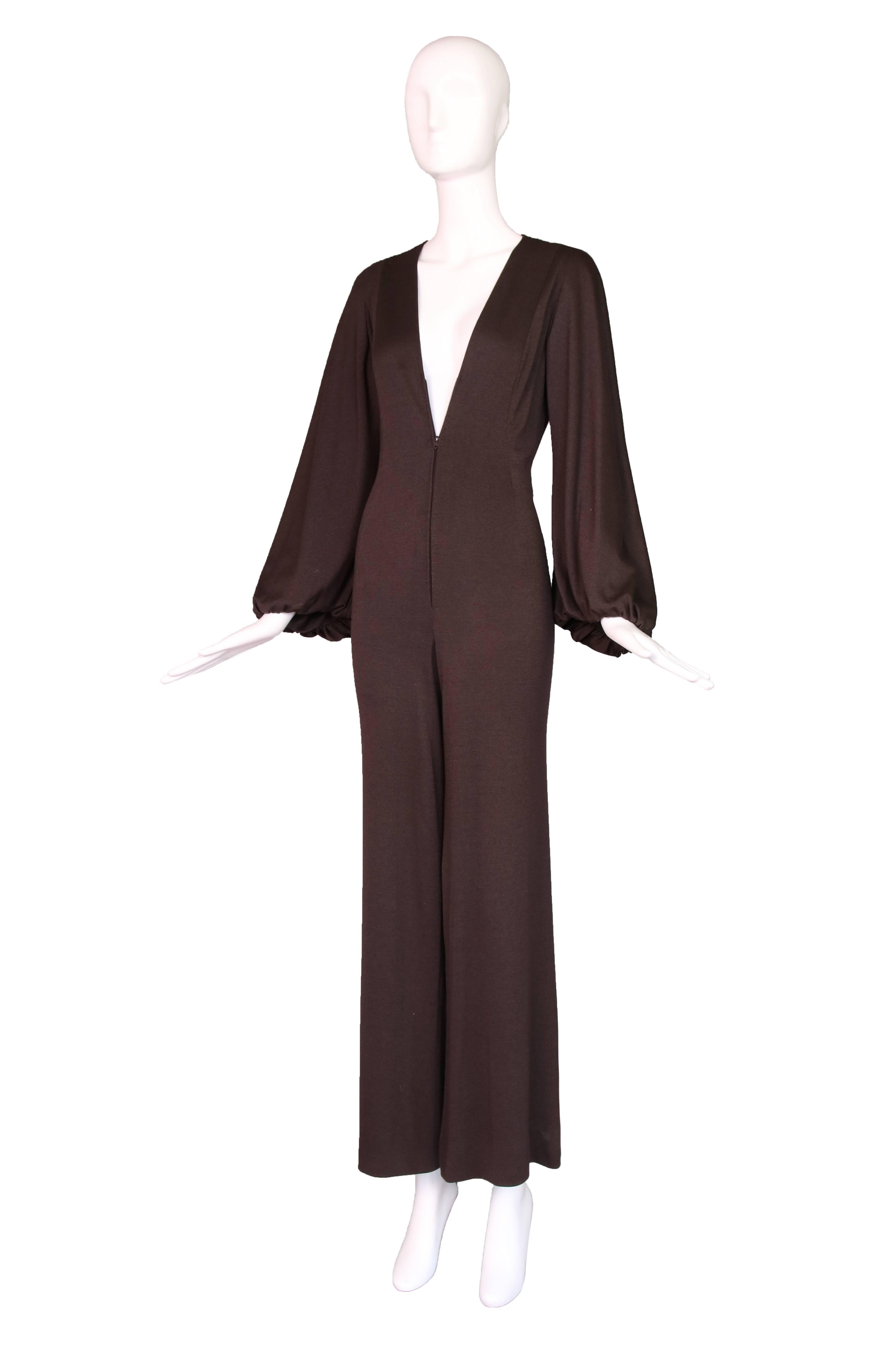 1970's Pauline Trigere brown medium-weight wool jersey jumpsuit with double-faced bell sleeves, pants that drape/flare below the knee and a frontal bodice zipper closure that intersects that a deep V-neckline. In very good to excellent condition -
