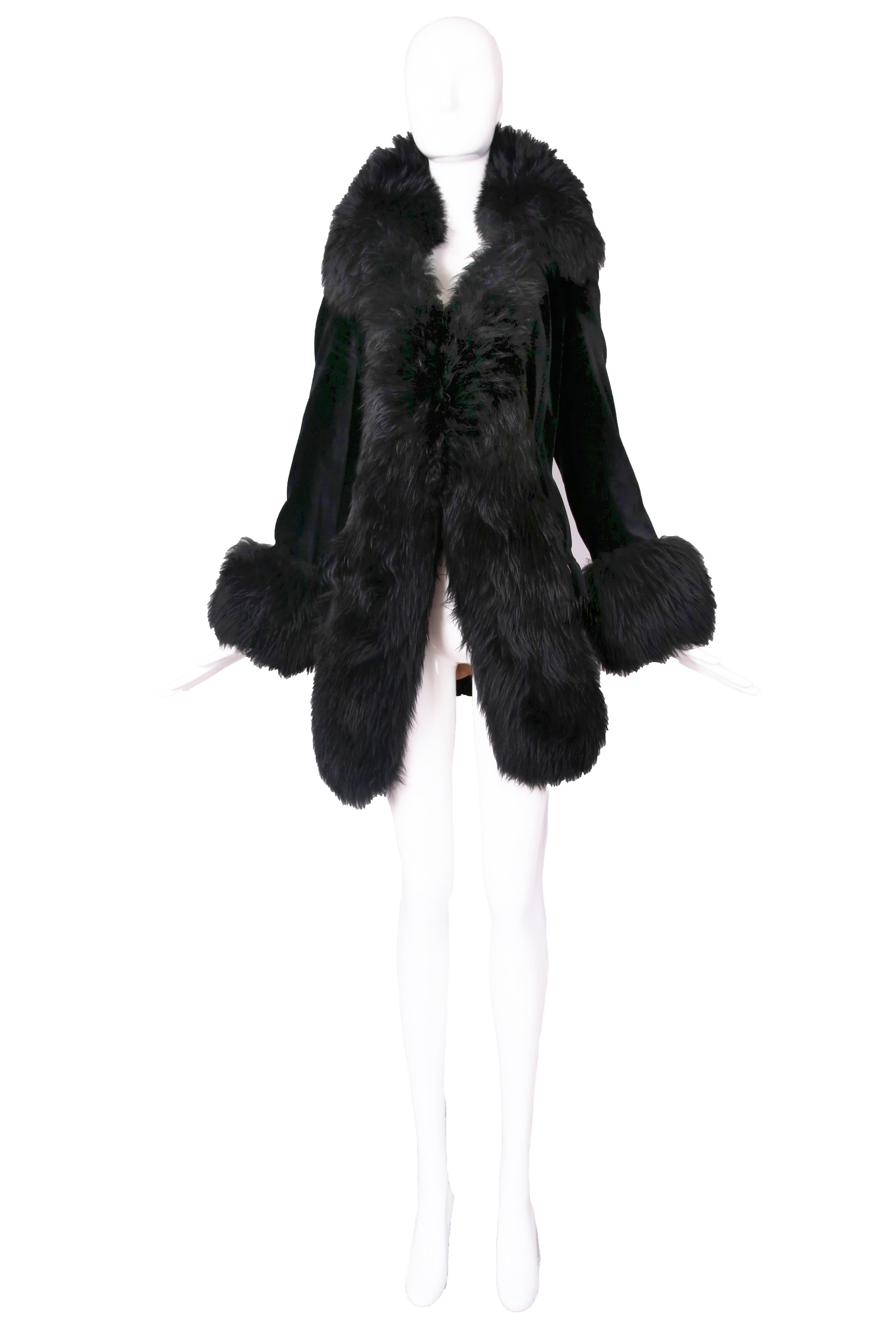 1990's Vivienne Westwood dramatic black velvet jacket with oversized faux fur trim at opening, collar, and cuffs. Size 40
MEASUREMENTS:
Shoulders - 16