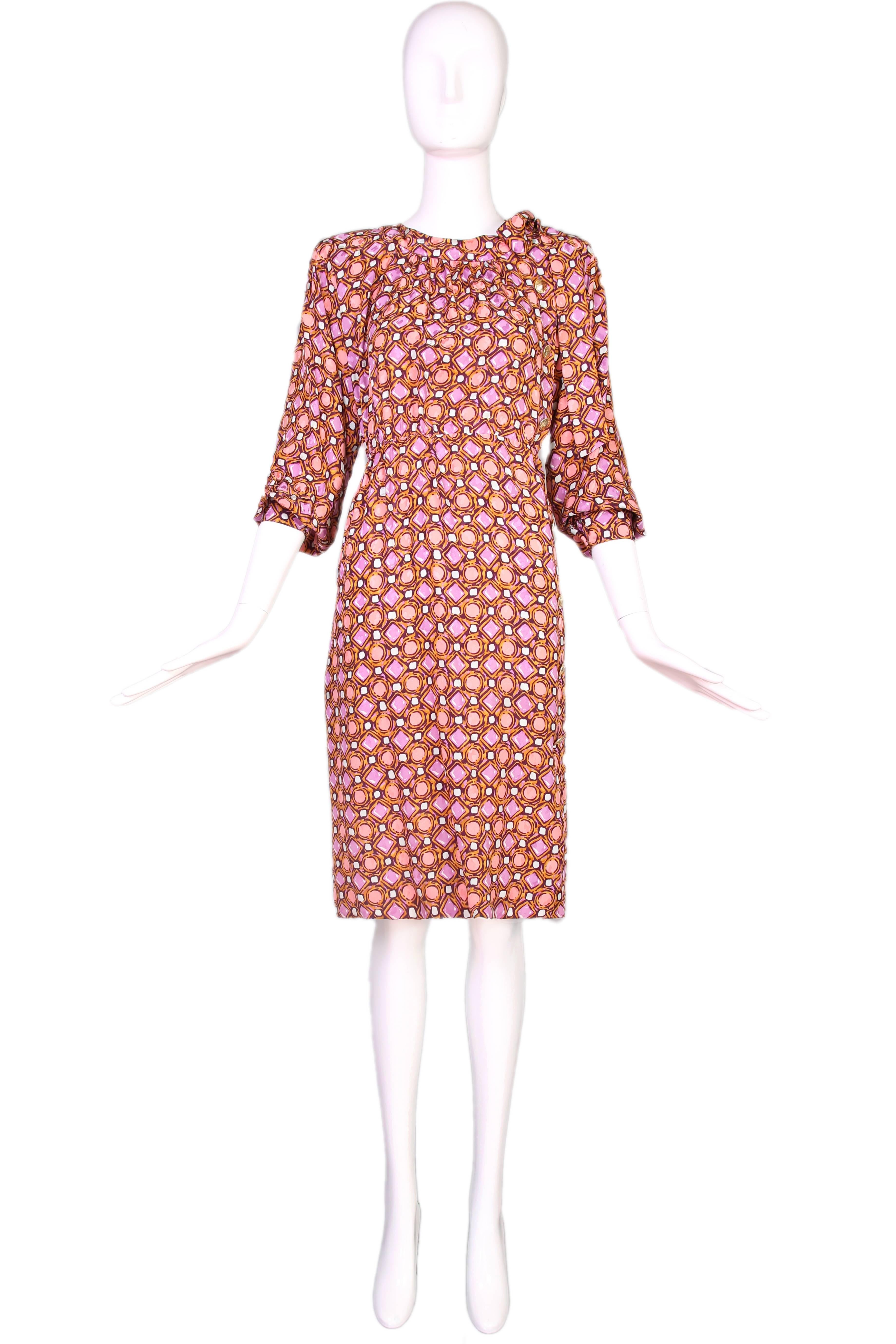 1984 Yves Saint Laurent silk day dress in orange, purple, and grey geometric print with long side neck ties and gold tone etched button closures down center left side. See original archival runway photographs in listing. In excellent condition. Size