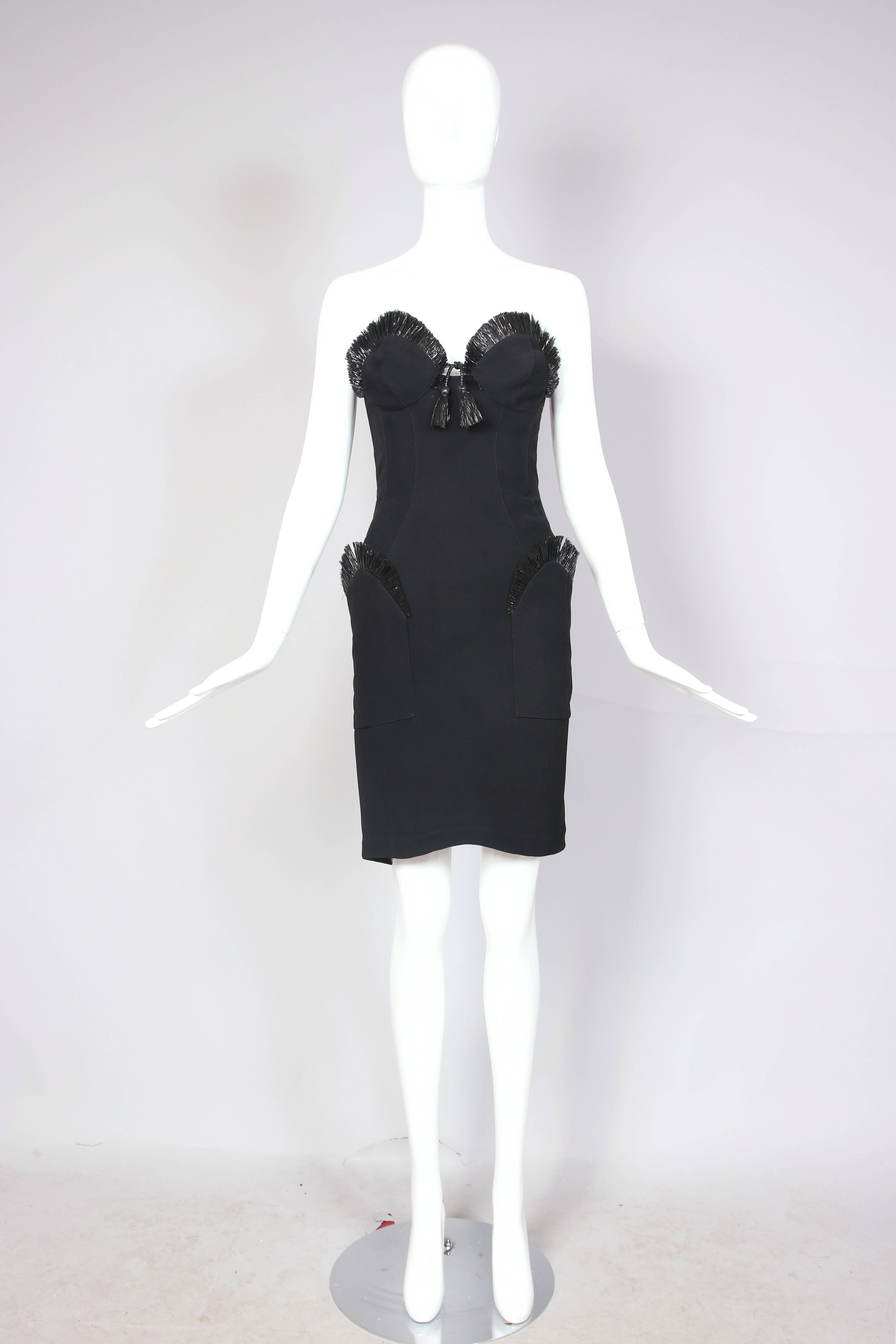 Iconic Thierry Mugler black rayon blend cocktail dress with architectural construction - featuring raffia trim at pocket edge, bodice edge and ending in tassel detail at dip in bust. Subtle waterfall shape at front hem. In excellent condition -