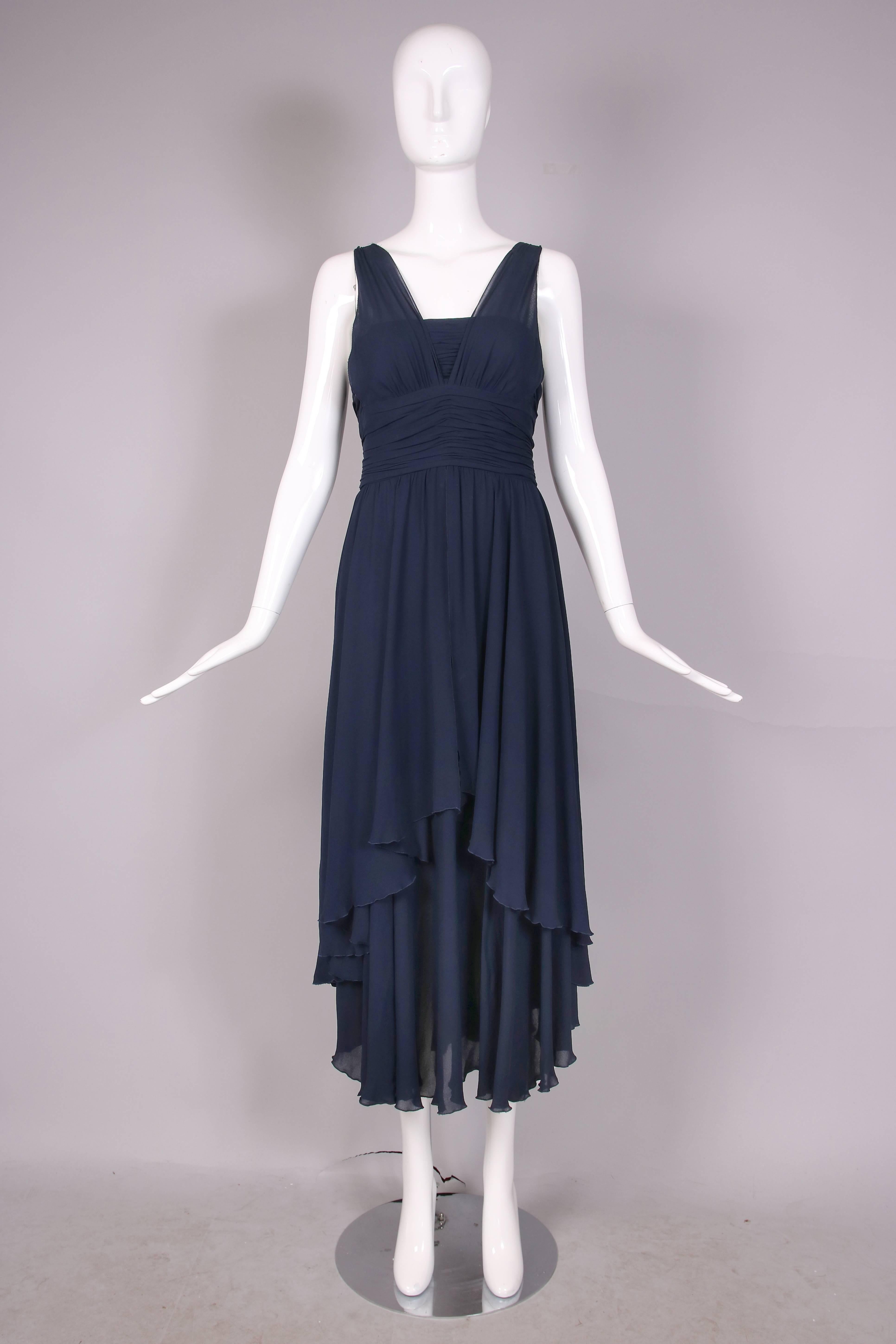 Vintage Chanel navy sheer crepe multi-layered evening dress with twin waterfall hem design at front and back and back bodice straps made out of iconic Chanel leather & chain. There is a zipper closure at bodice back which   features decorative CC