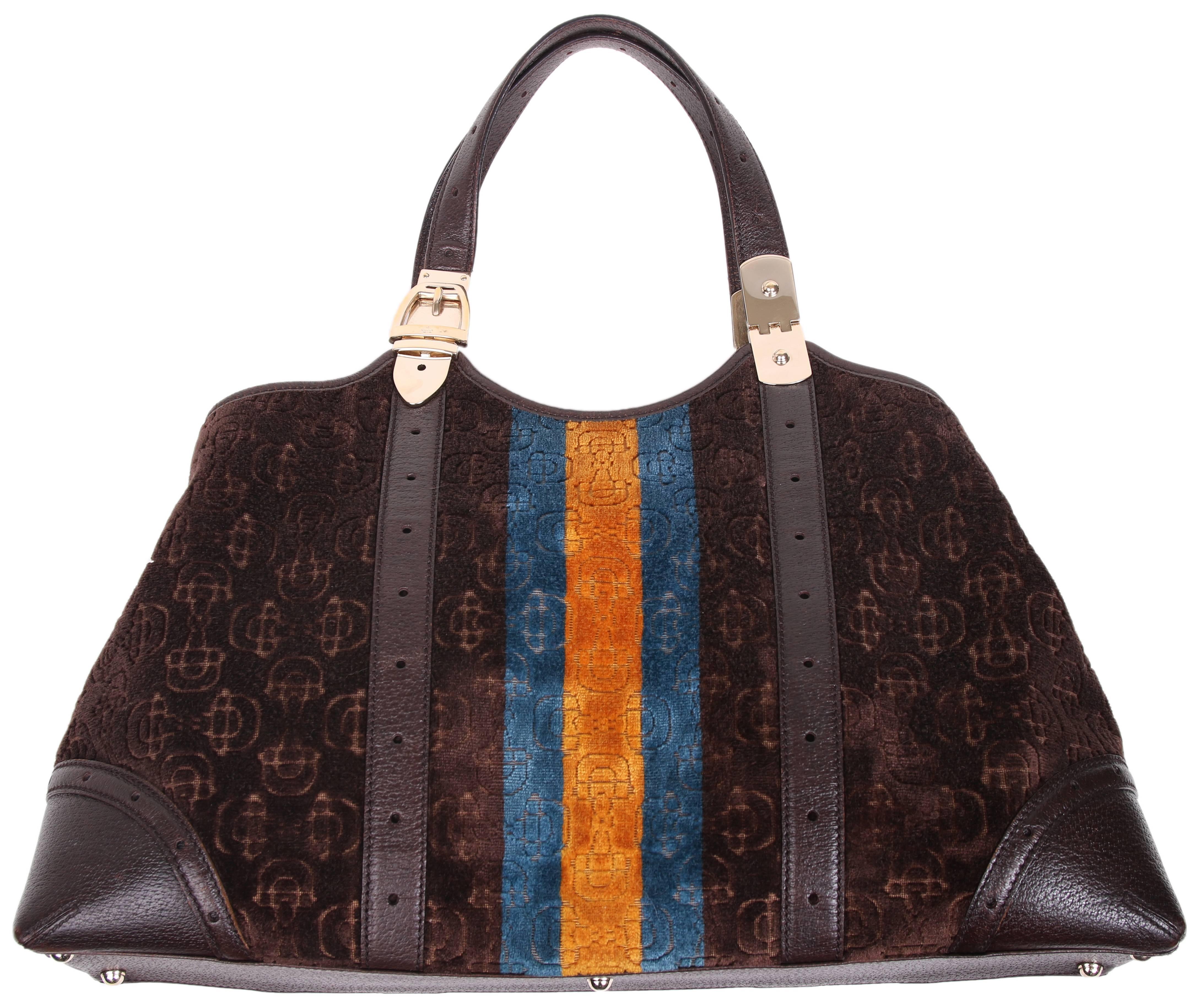 Gucci horse bit logo cut velvet handbag with leather straps and trim. Bag features a teal and burnt orange racer stripe down center front and back and the hardware is a light gold. Interior has plenty of room and features a zippered wall pocket.