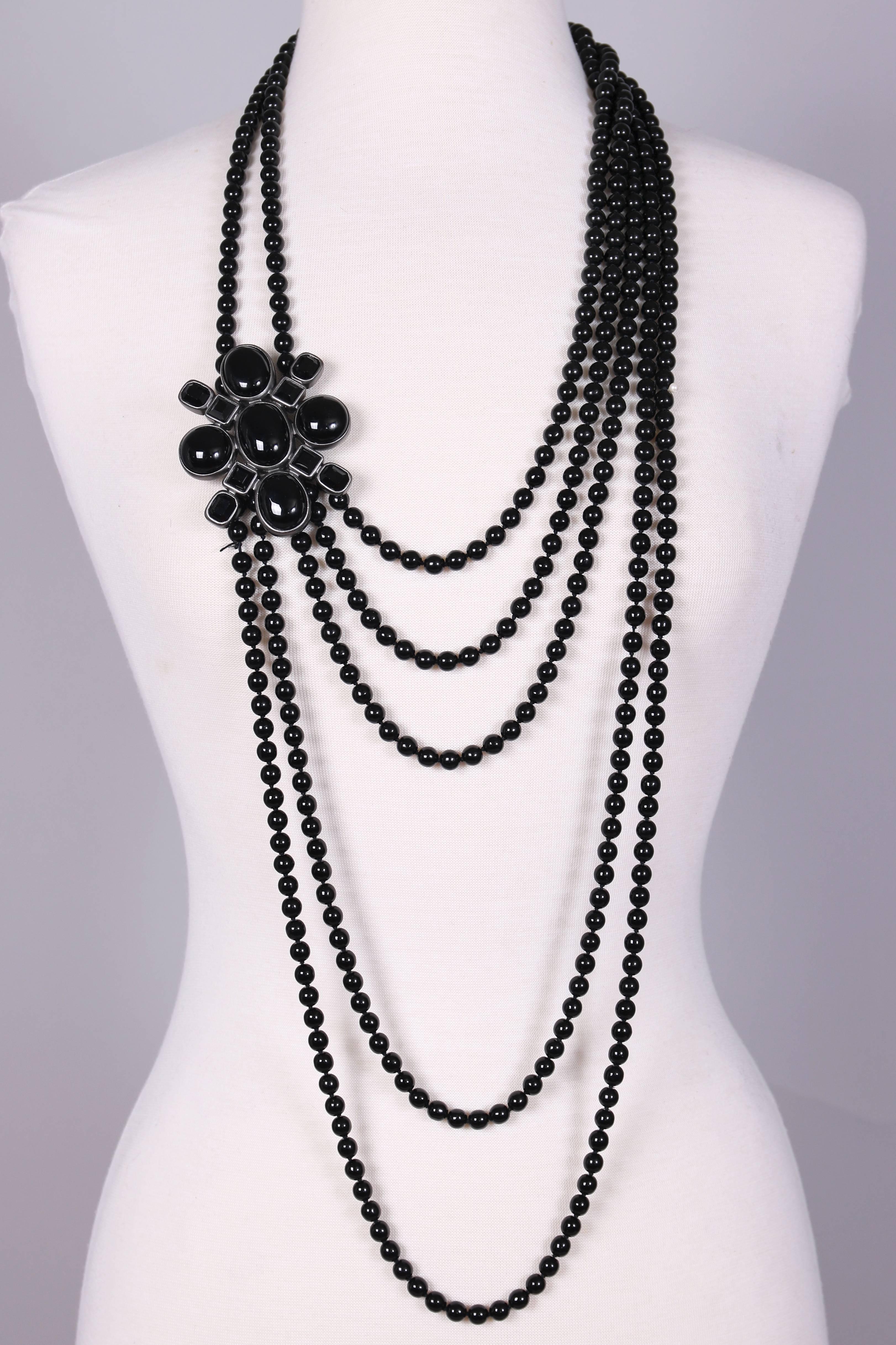 2005 Chanel multi-strand black Patte De Verre bead sautoir necklace attached to broach set w/ Patte De Verre cabochon and faceted beads. Cartouche on back with stamped 