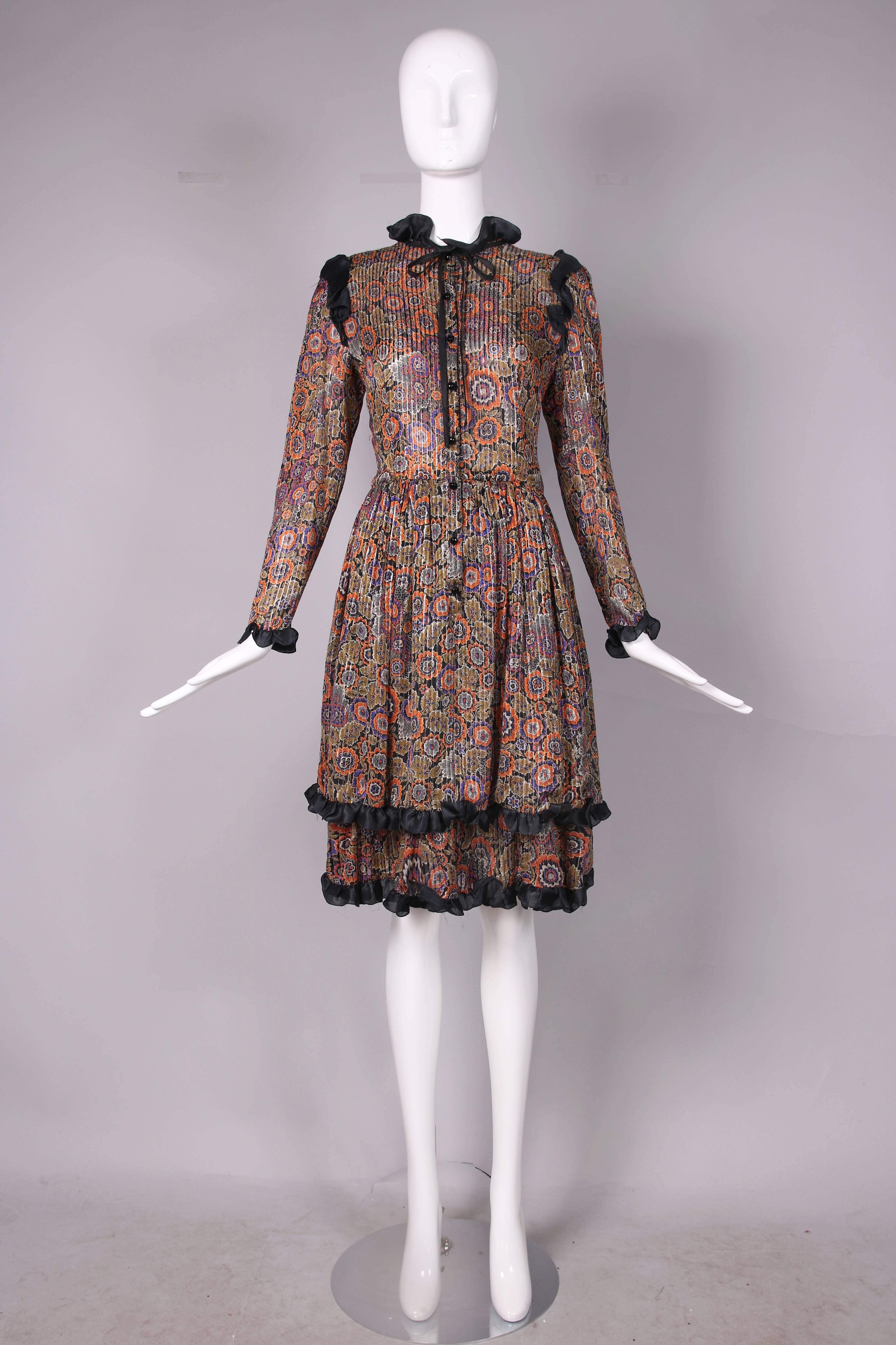 Vintage Valentino silk day dress in a black, purple, orange, white and olive floral print run through with vertical gold metallic threads. Dress features a nipped waist, tiered skirt, faceted black buttons at center front and cuffs, neck ties that