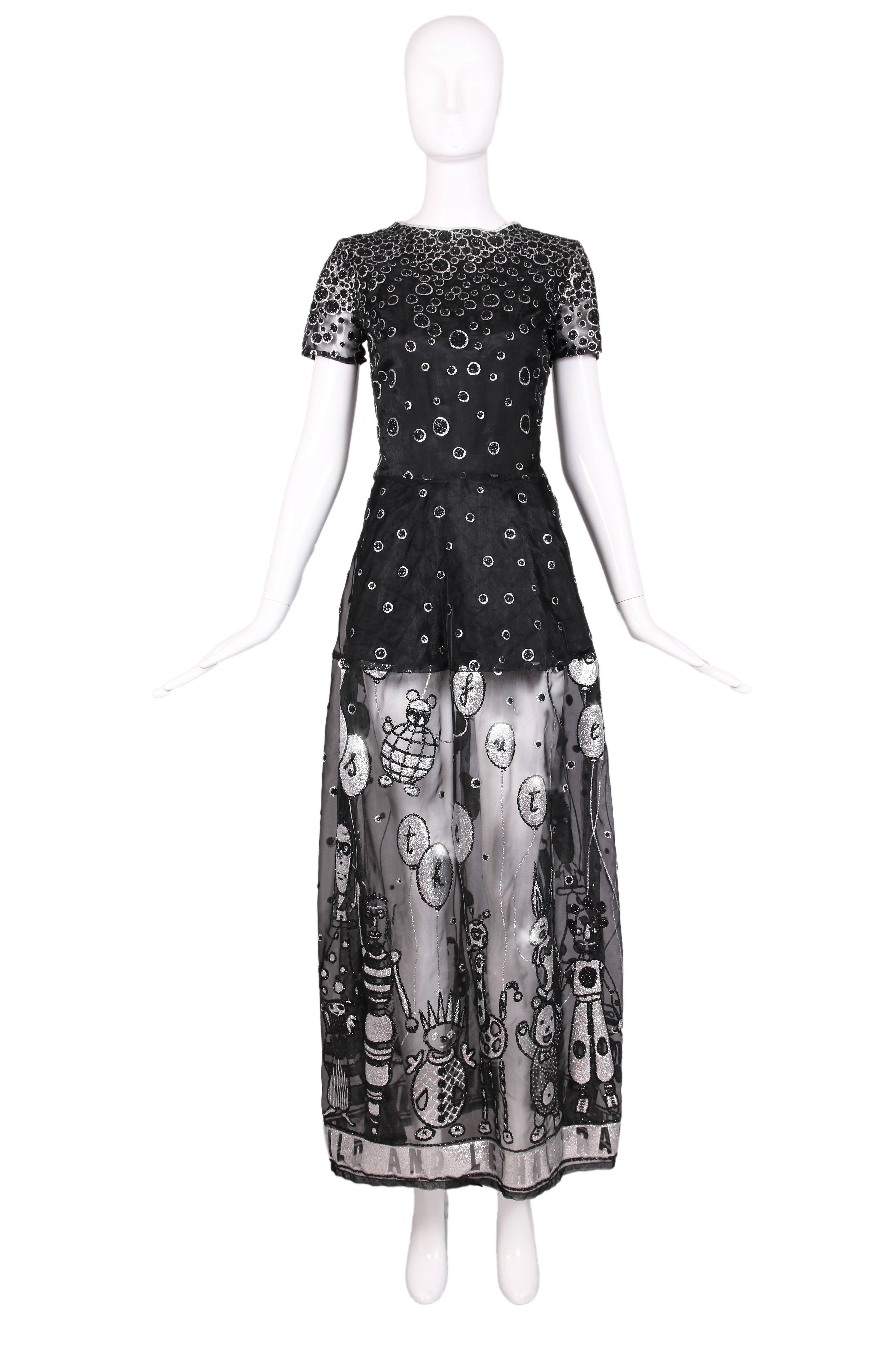 1990's Walter Van Beirendonck "Wild & Lethal Trash" Label black organza overlay evening gown featuring black and silver glittered circle print at top and whimsical characters holding balloons with letters with a black mini dress