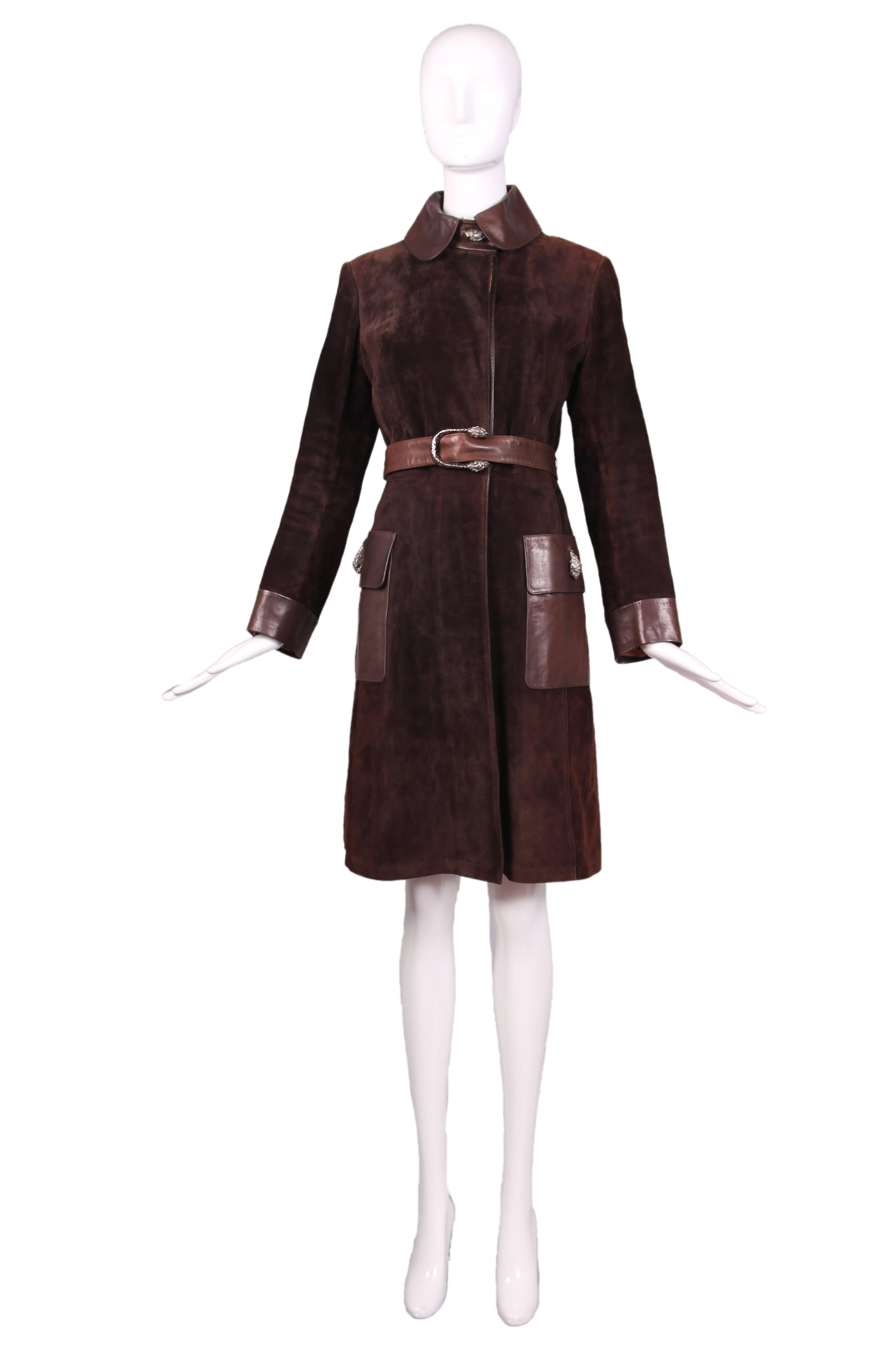 1970's Gucci brown suede coat with leather belt, trim, collar, cuffs, and two frontal pockets. Decorative sterling silver & enamel tiger heads at neck closure, patch pockets, and belt. Fully lined in silk with Gucci logo pattern. In excellent