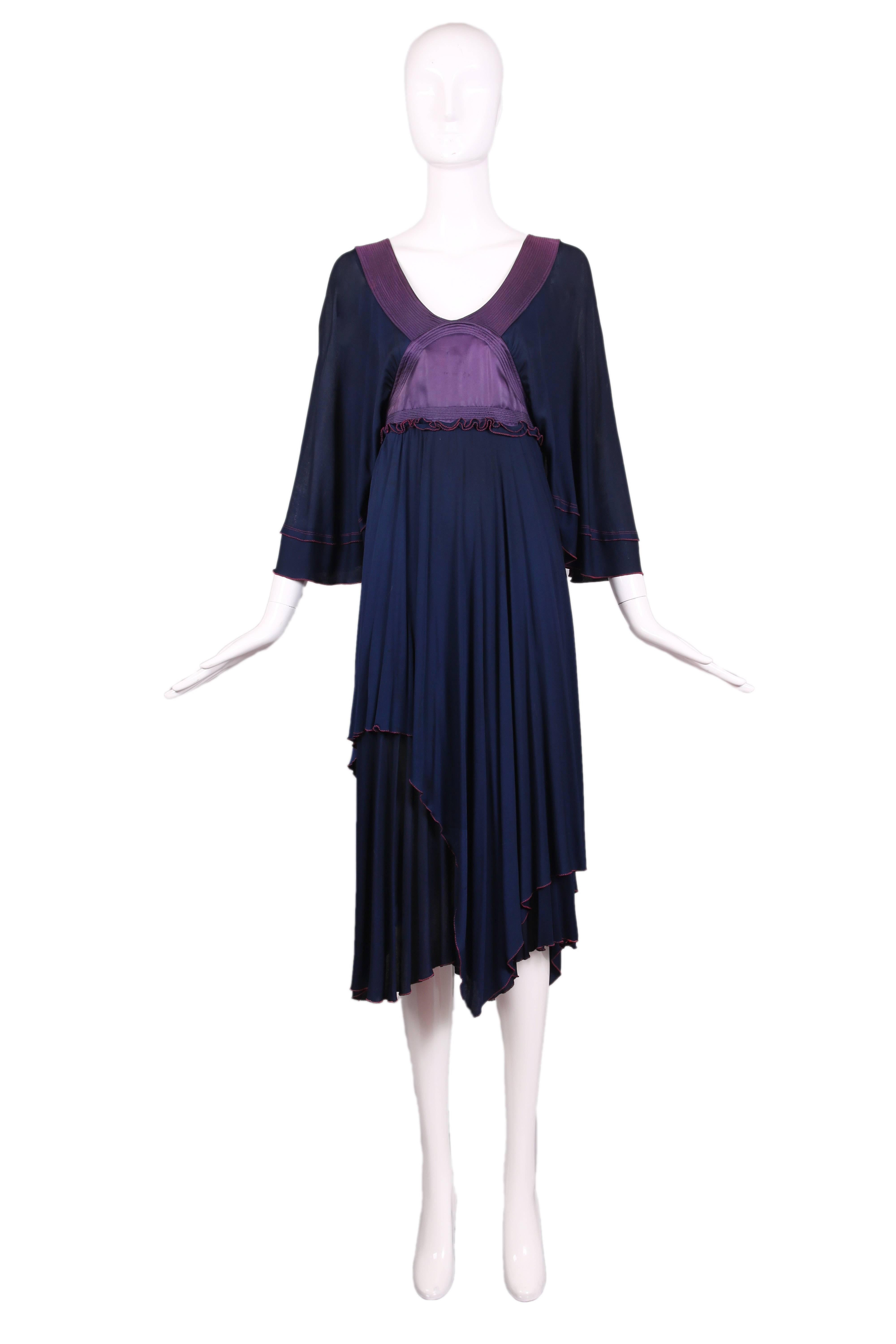 Vintage Zandra Rhodes navy and purple empire waist dress with bat wing sleeves and a wide scoop neck with quilted silk band. Multi-layered rough-cut hemline and lettuce edge with fabric button closures up the side. In good condition with tiny